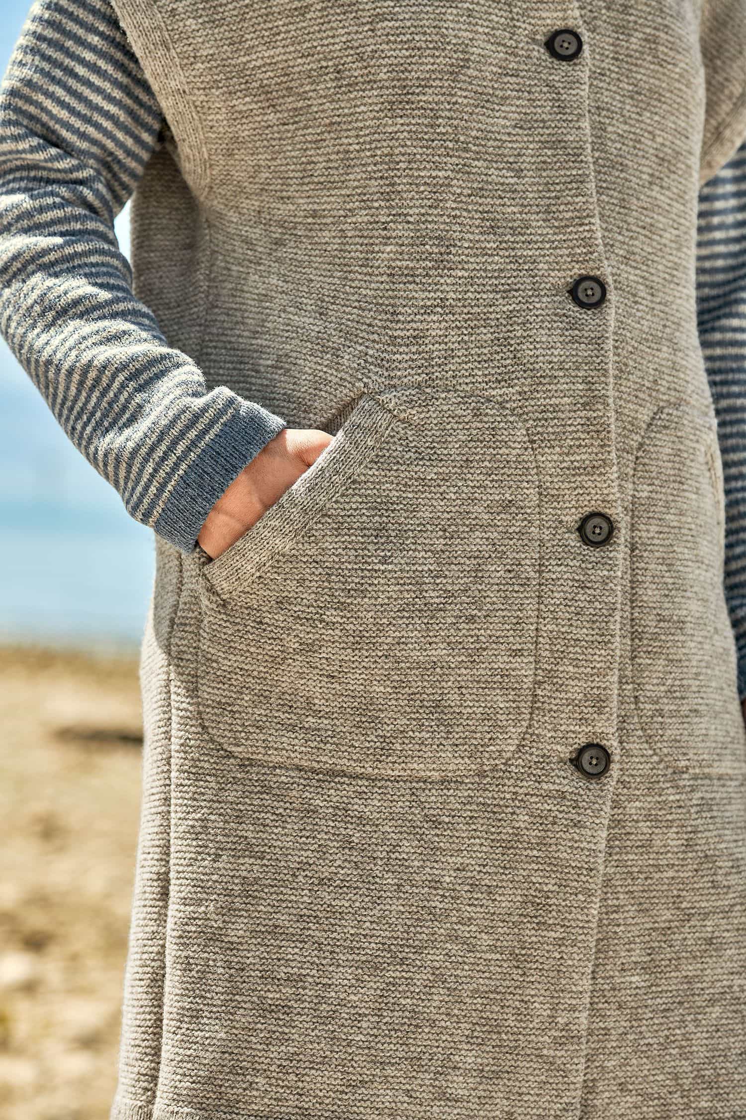 Detailansicht der Knöpfe und der Tasche der grauen langen Damenstrickweste vom Finkhof aus bio Merinowolle (kbT)