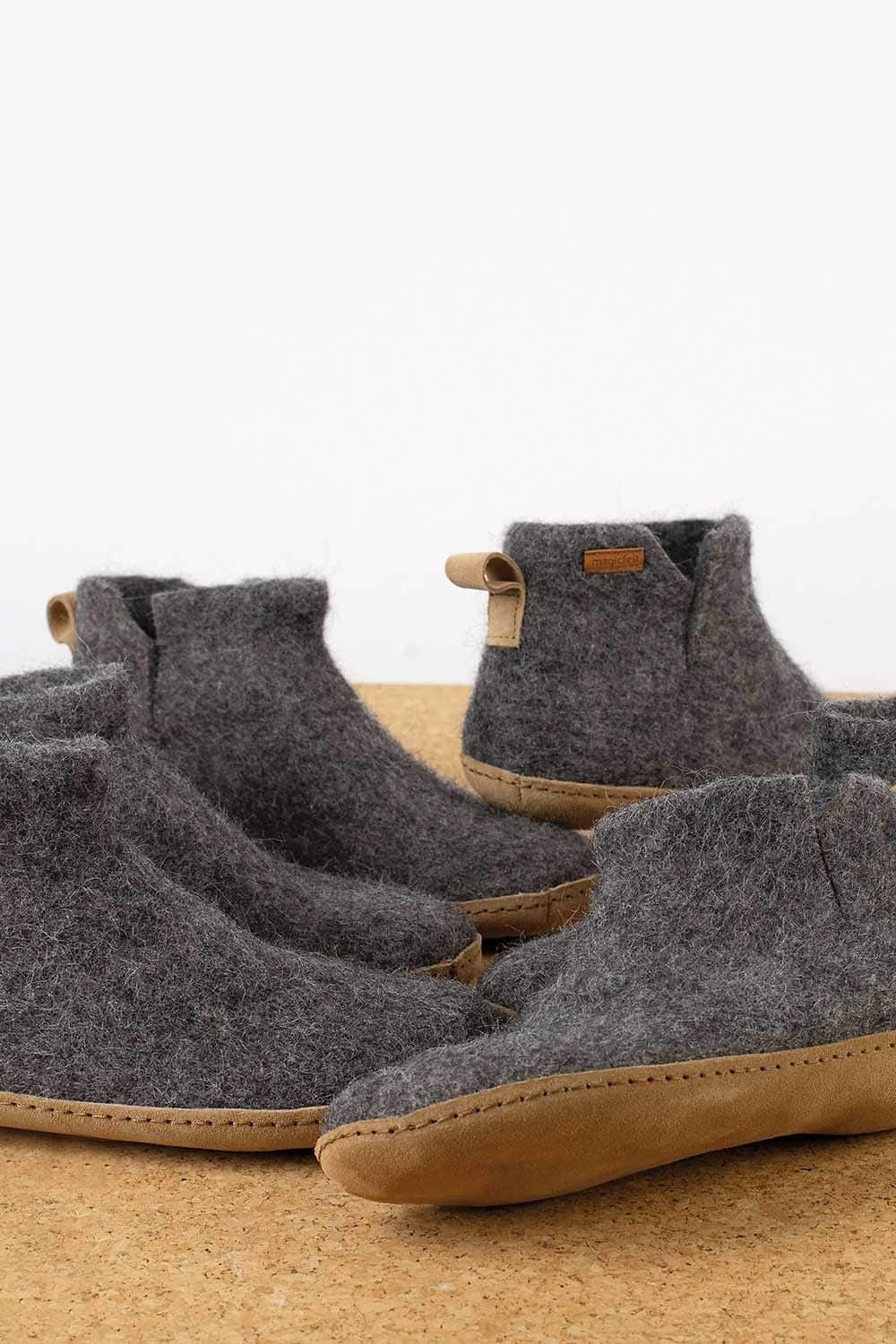 mehrere Paare graue Filzstiefel mit einer Sohle aus Rindsleder, Kork und Wolle