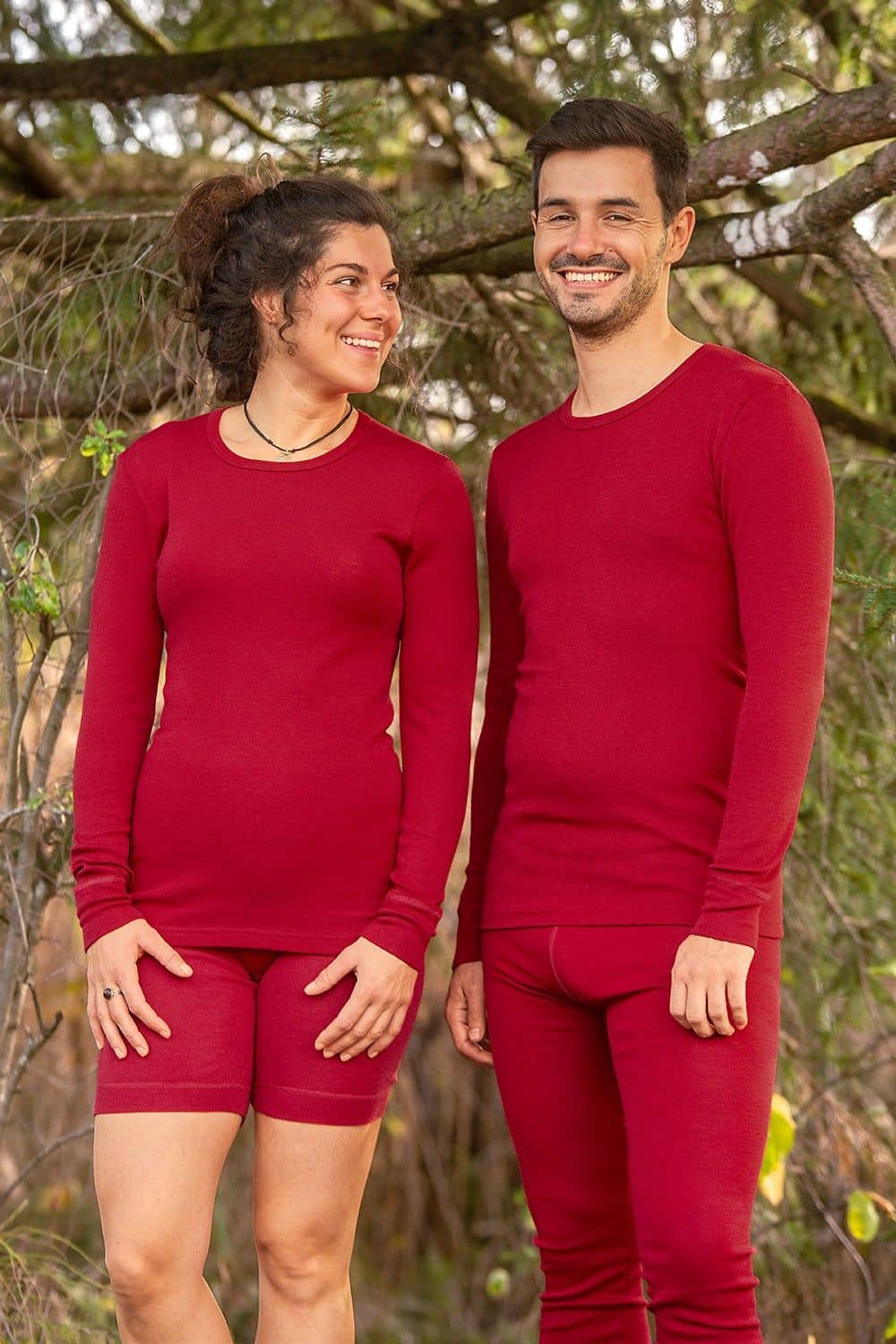 Mann und Frau tragen rote langärmelige Wollshirt aus bio Wolle (kbT) mit passenden Hosen