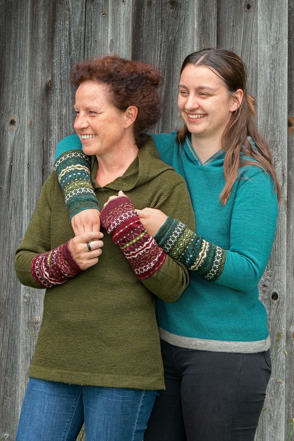 Frauen tragen rote und grüne Armstulpen im nordischen Muster mit Jeans und einfarbigen Pullis