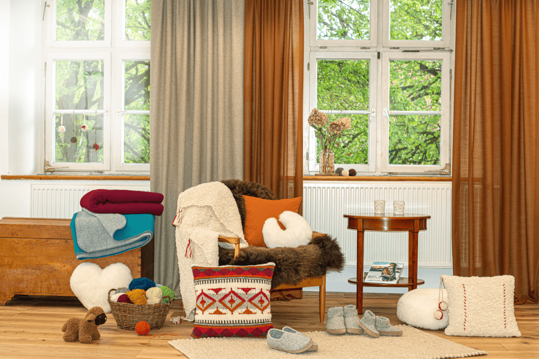 Stimmungsbild von Wohnzimmer mit vielen Decken, Kissen und Finkhof Produkten