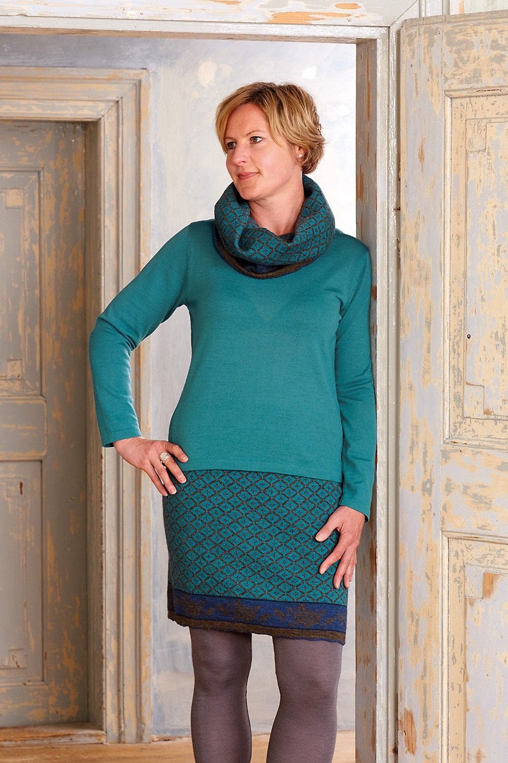 Frau mit gemustertem Rock und Schal trägt türkises Wollshirt aus bio Wolle (kbT) vom Finkhof