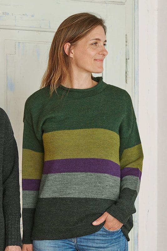 Frau trägt grünen Blockstreifenpullover aus bio Wolle (kbT)