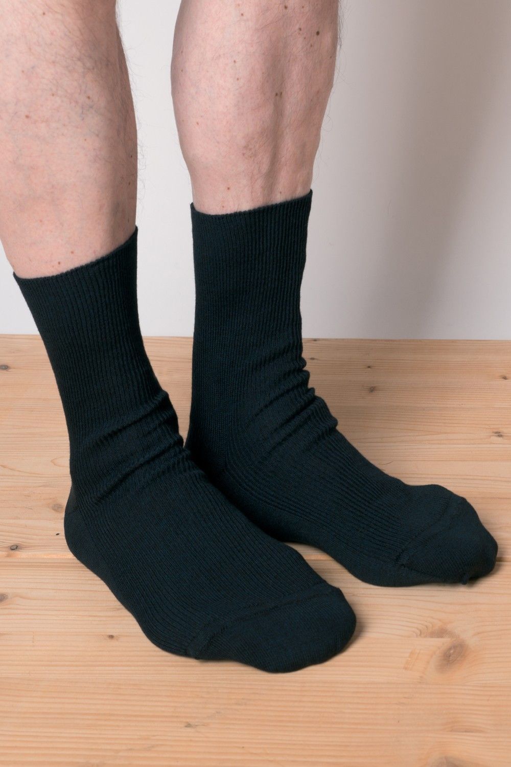 Venensocken aus Schurwolle und Bio-Baumwolle Model trägt schwarze Venensocken aus bio Baumwolle (kbA) und Wolle