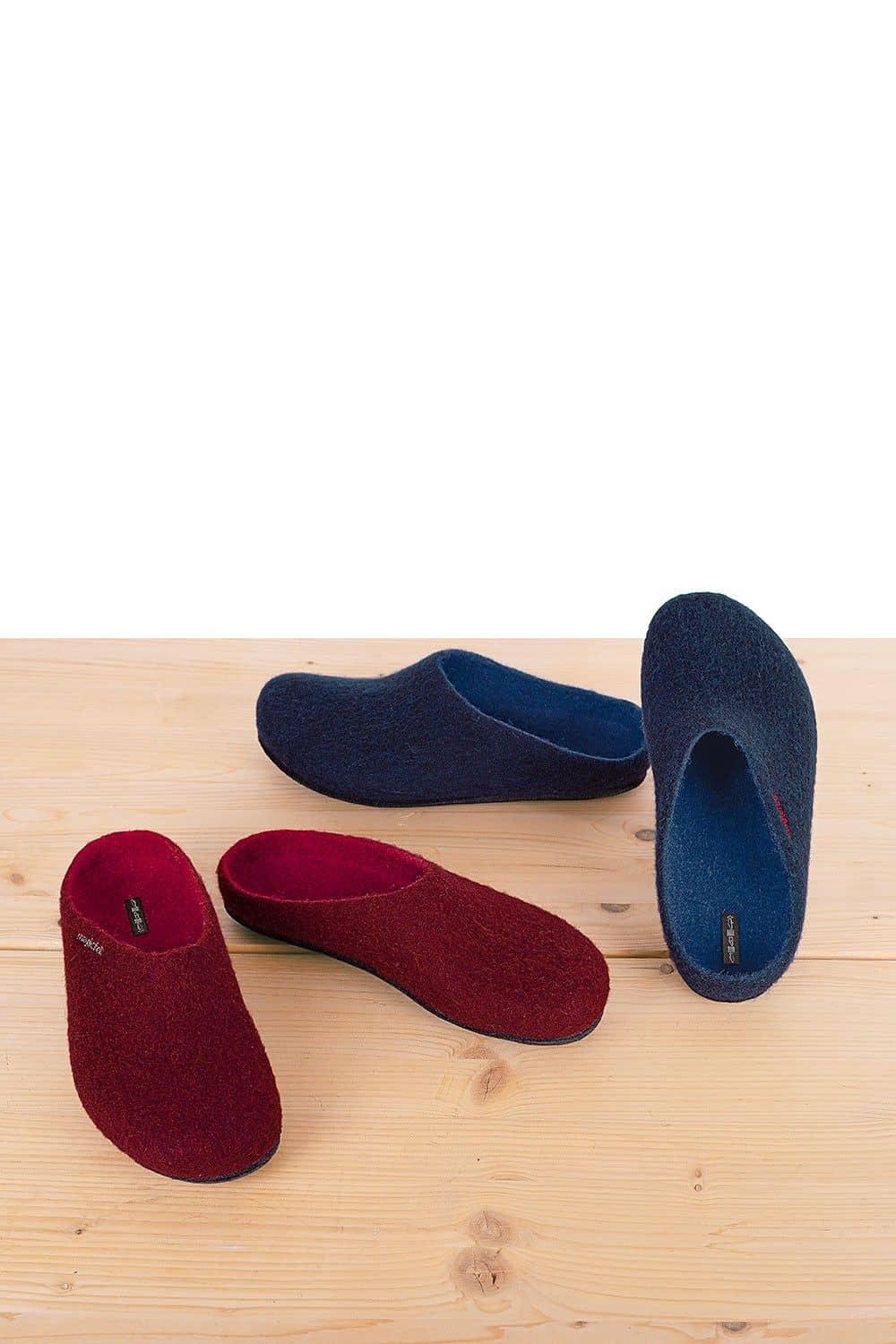 dunkeblaue und dunkelrote Filzhausschuhe auf hellbraunem Holzboden