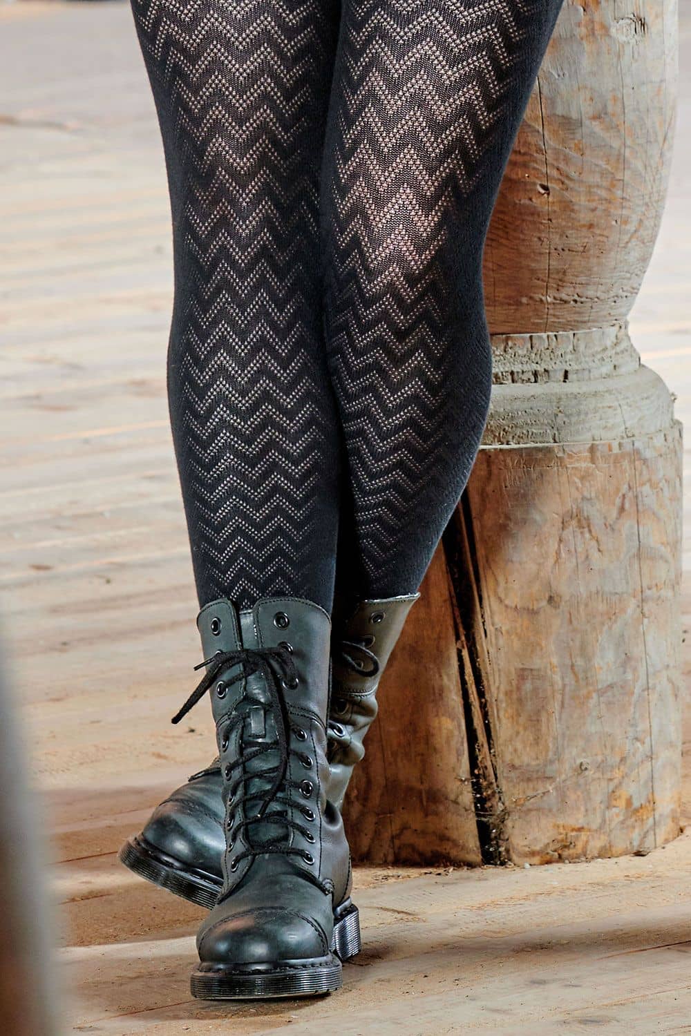 Ajour-Leggings schwarze Ajourleggings aus bio Baumwolle (kbA) und Elasthan mit schwarzen Stiefeln und Holzhintergrund