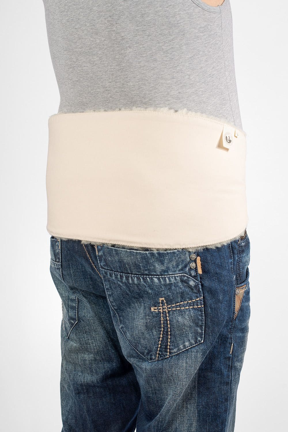 Mann von Seite mit Top, Jeans und weißem relugan gegerbtem Finkhof Rückenwärmer aus Schaffell und bio Baumwolle (kbA)