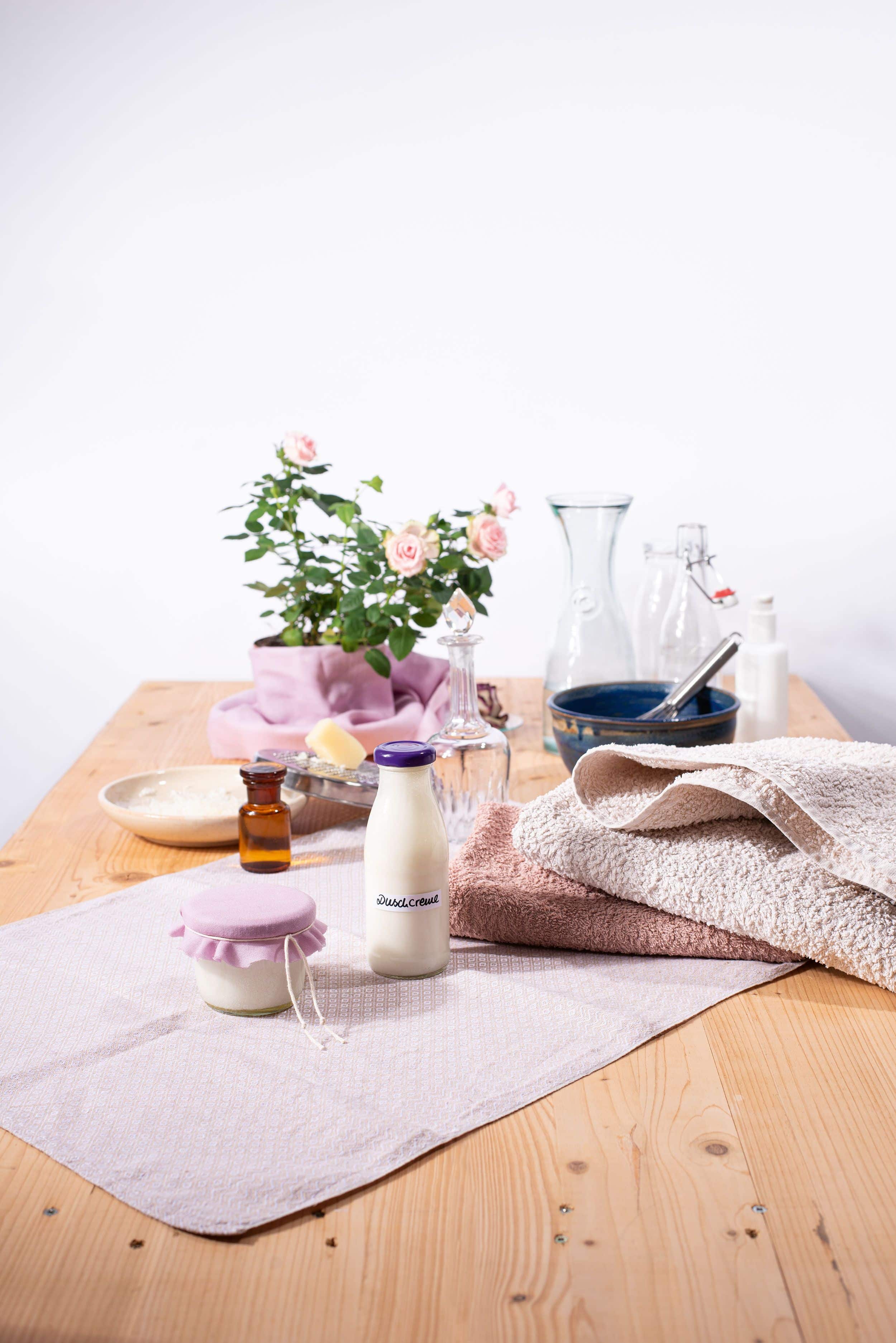 abgefüllte Duschcreme auf Tisch mit Zutaten im Hintergrund