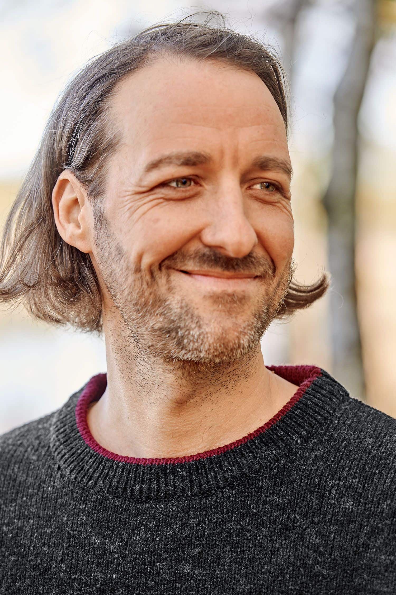 Portraitaufnahme von Mann mit dunkelgrauem Pullover aus bio Wolle (kbT) vom Finkhof