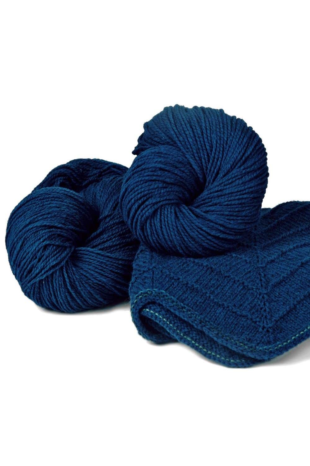 Finkhof Merinowolle dünn gefärbt dunkelblau dünne dunkelblaue Finkhof Merinowolle aus bio Wolle (kbT) mit Strickstück davor, weißer Untergrund