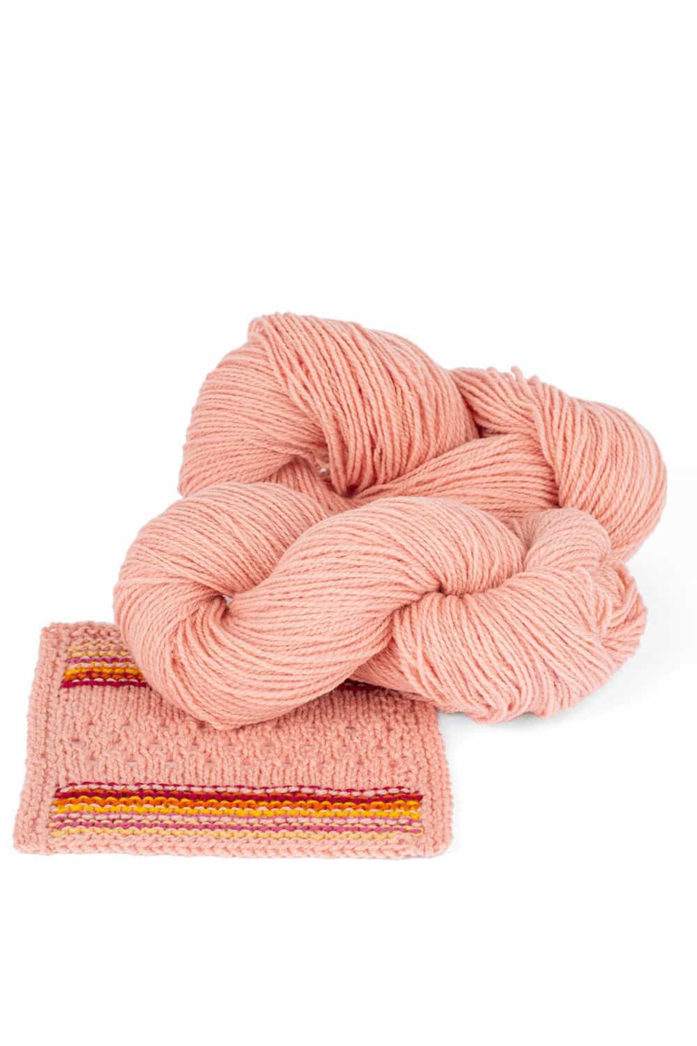 Finkhof Merinowolle dick gefärbt pastellrosa dicke pastellrosane Finkhof Merinowolle aus bio Wolle (kbT) mit Strickstück davor, weißer Untergrund