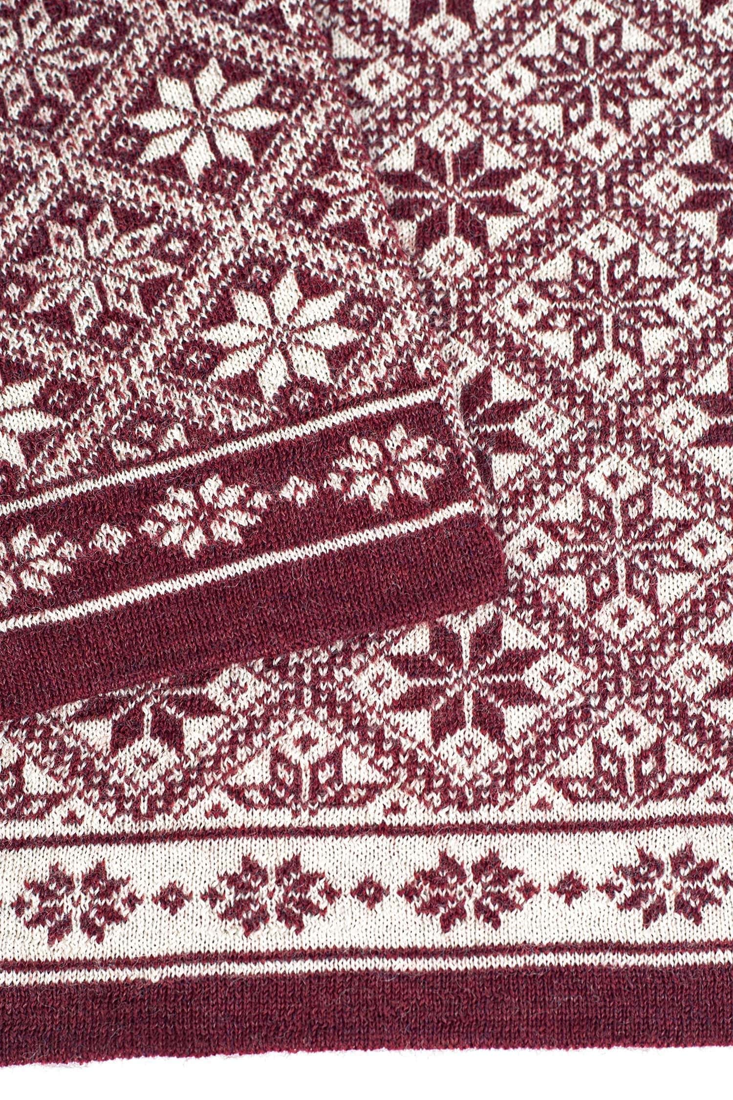 Nahaufnahme vom Muster des burgunderroten Schals mit winterlichem Muster aus bio Wolle (kbT)