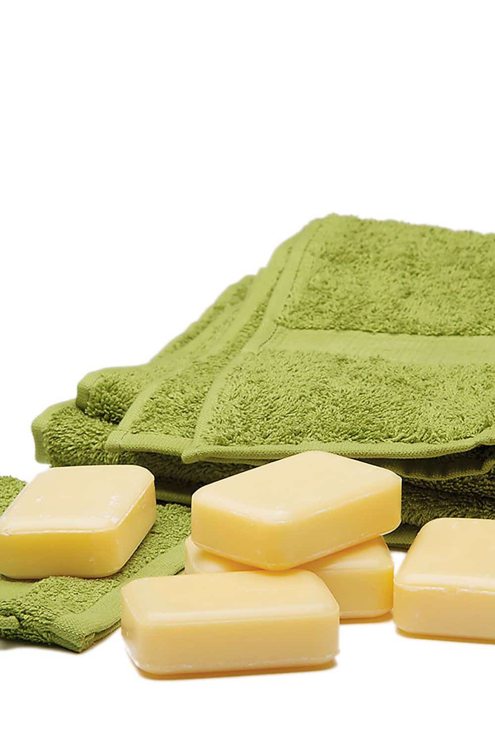 grüne Handtücher aus bio Baumwolle (kbA) auf einem Stappel und blockseifen davor