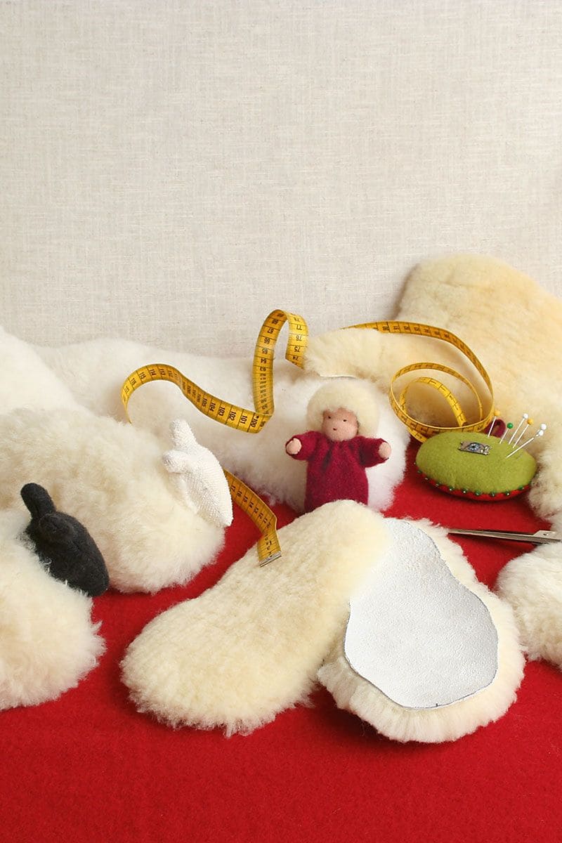 Fellreste vom Finkhof mit Maßband und Nadeln auf rotem Untergrund