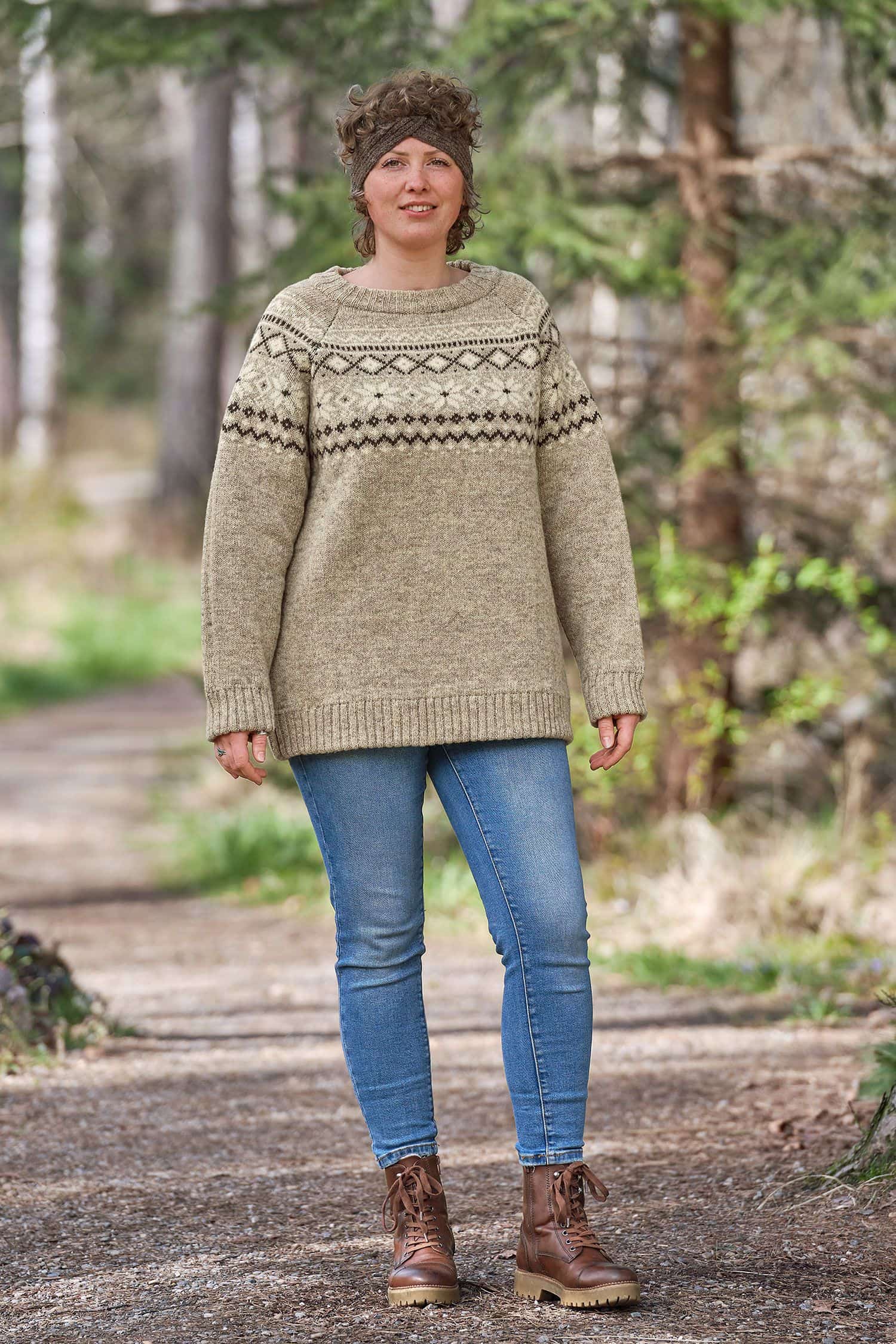 Frau mit Stirnband und Jeans trägt grauen Finkhof Norwegerpulli aus bio Wolle (kbT)