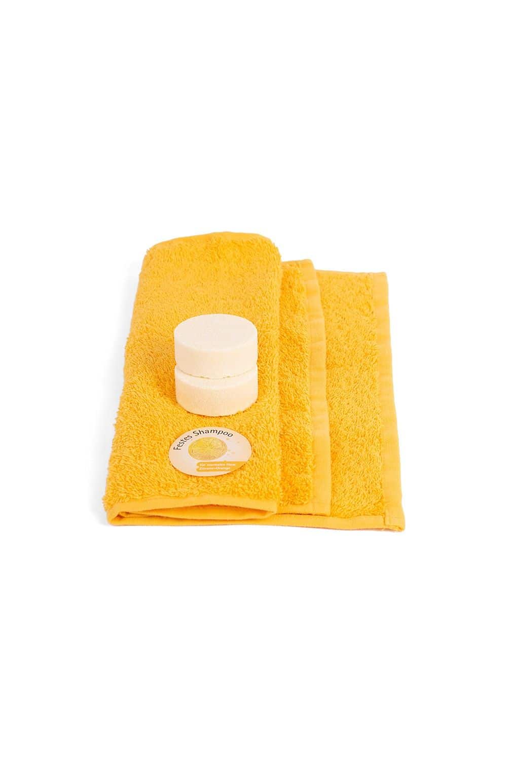 Festes Shampoo lose Zitrone-Orange festes Shampoo mit Zitronen-Orangen Duft liegt auf einem gelben Handtuch