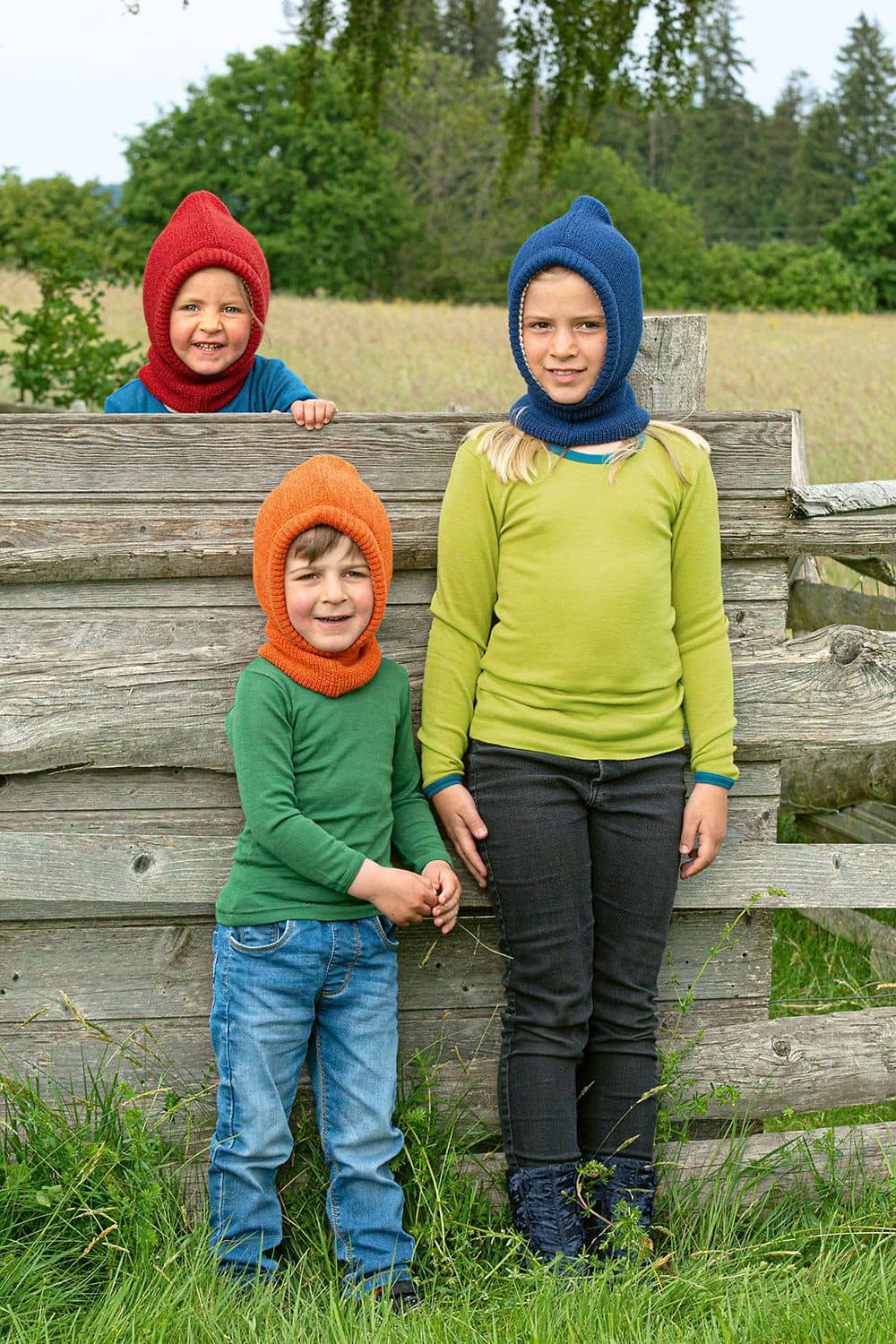 Schlupfmütze Kinder vor Zaun tragen Schlupfmützen vom Finkhof aus bio Wolle (kbT) und bio Baumwolle (kbA) in verschiedenen Farben