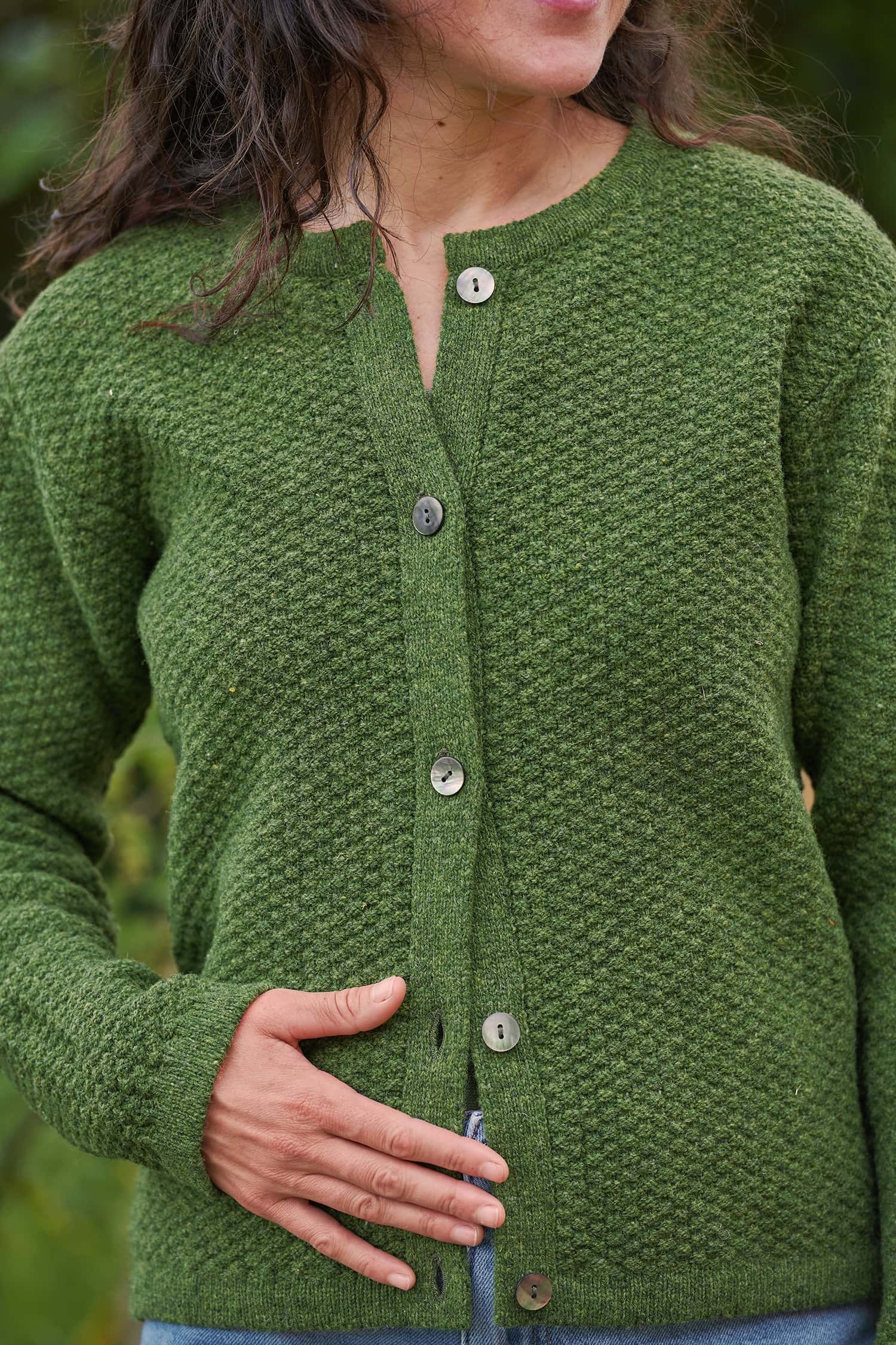 Finkhof-Strukturjacke aus reiner Bio-Schurwolle Frau trägt eine grüne Strickjacke mit Struktur aus Bio-Schurwolle vom Finkhof