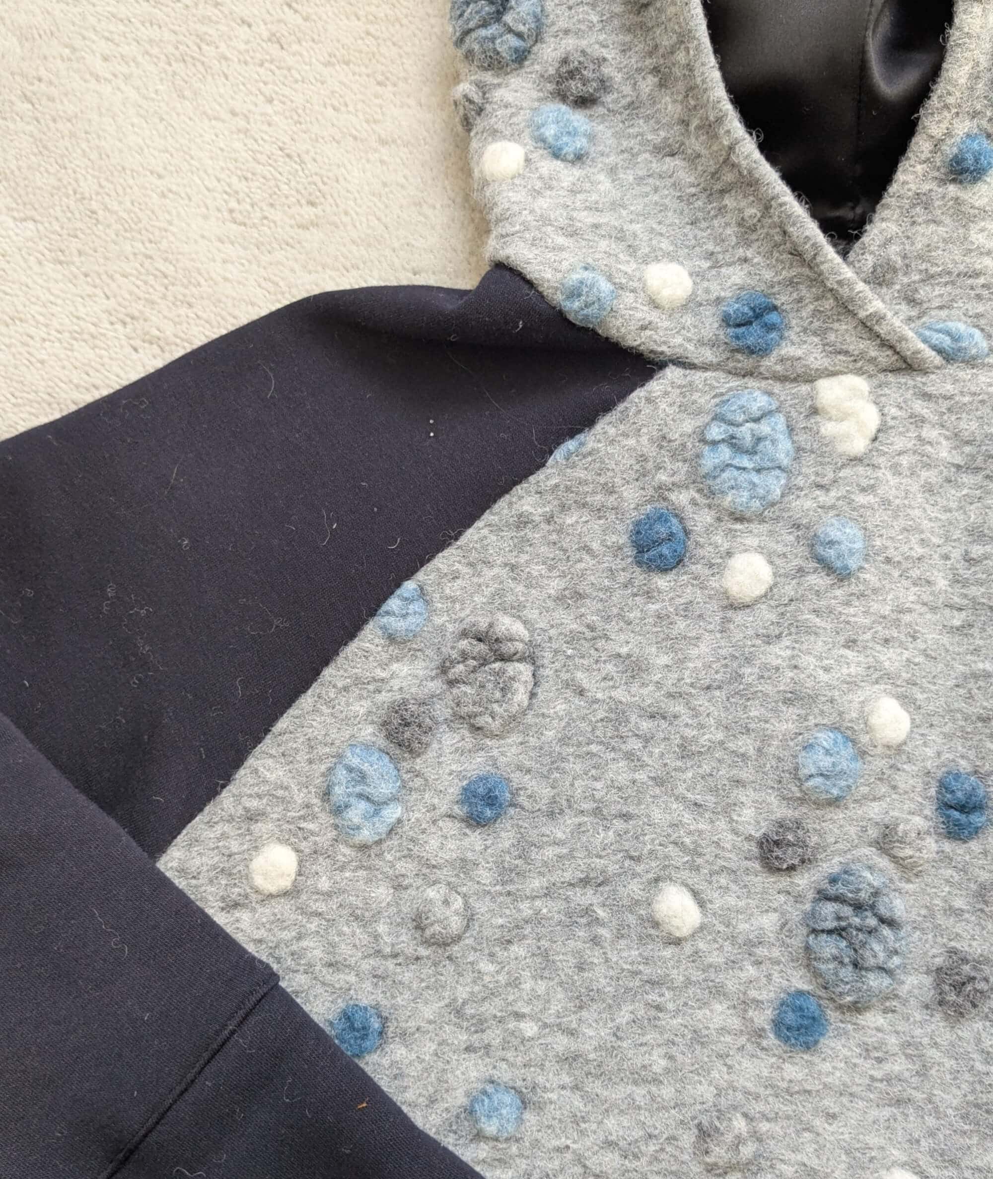 Detail der blauen Schulter eines Hoodies aus blau grauem Musterwalk