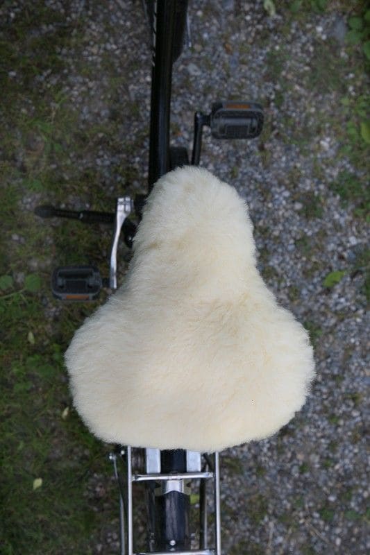 relugan gegerbter Finkhof Sattelbezug aus bio Wolle (kbT) und Schaffell auf dunklem Fahrrad von oben