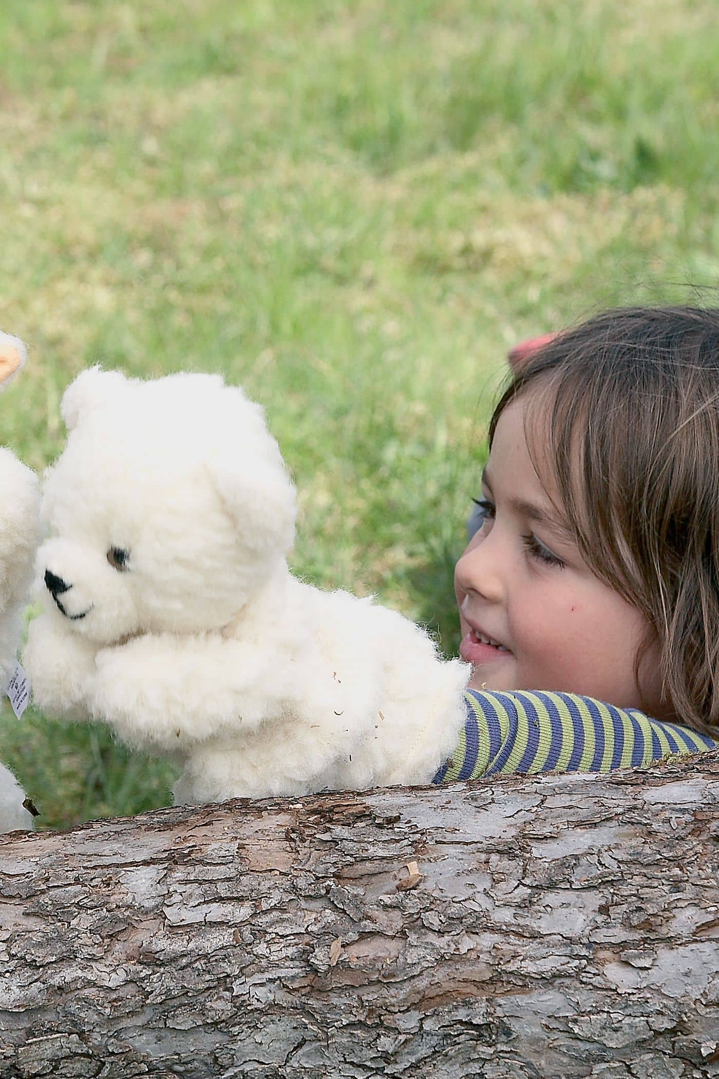 Handpuppe Eisbär weiße Eisbären Handpuppe wird von Kind mit gestreiftem Shirt hinter Baumstamm gehalten