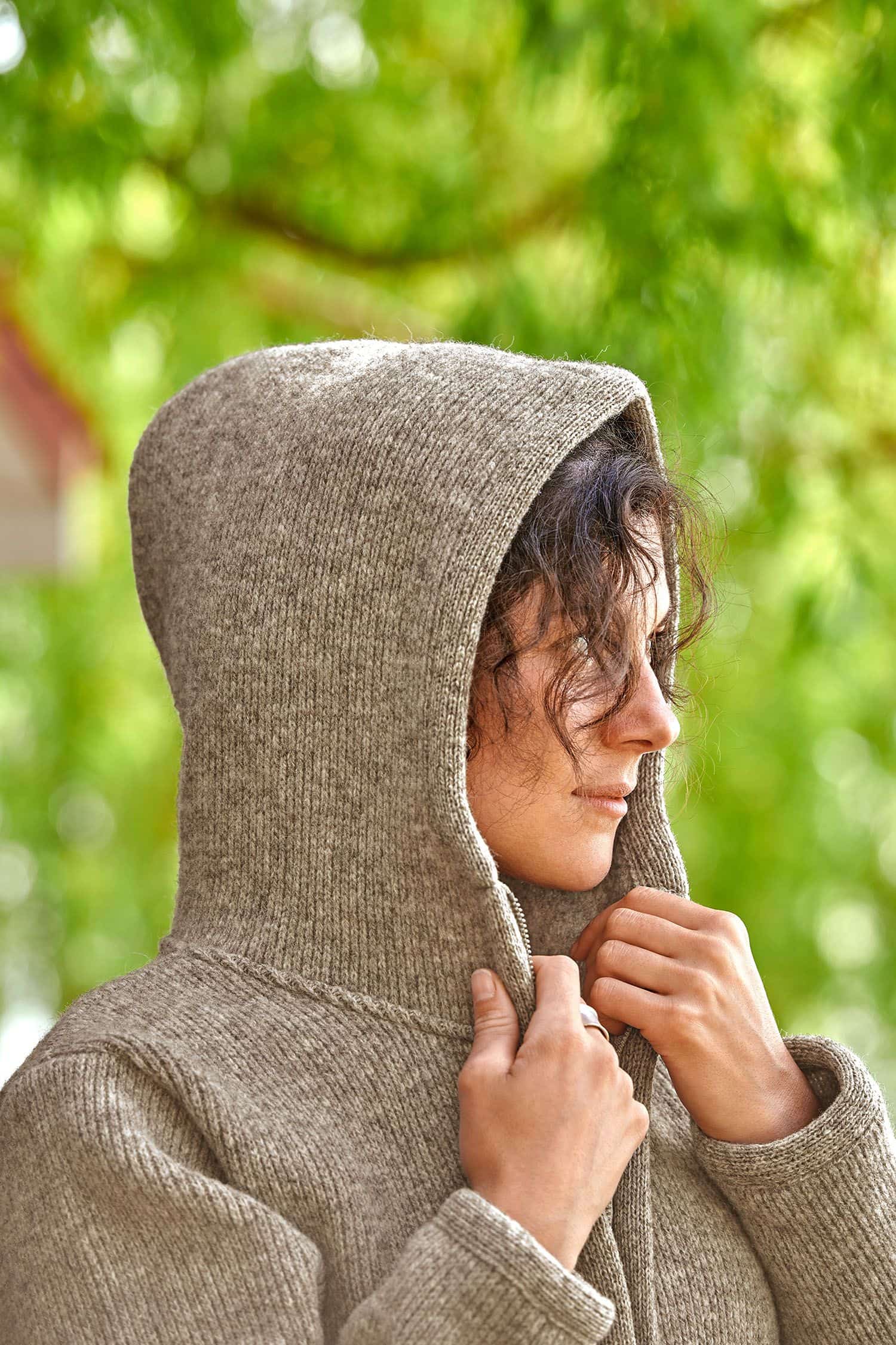 Frau trägt die Kapuze der grauen Finkhof Jacke aus bio Wolle (kbT)