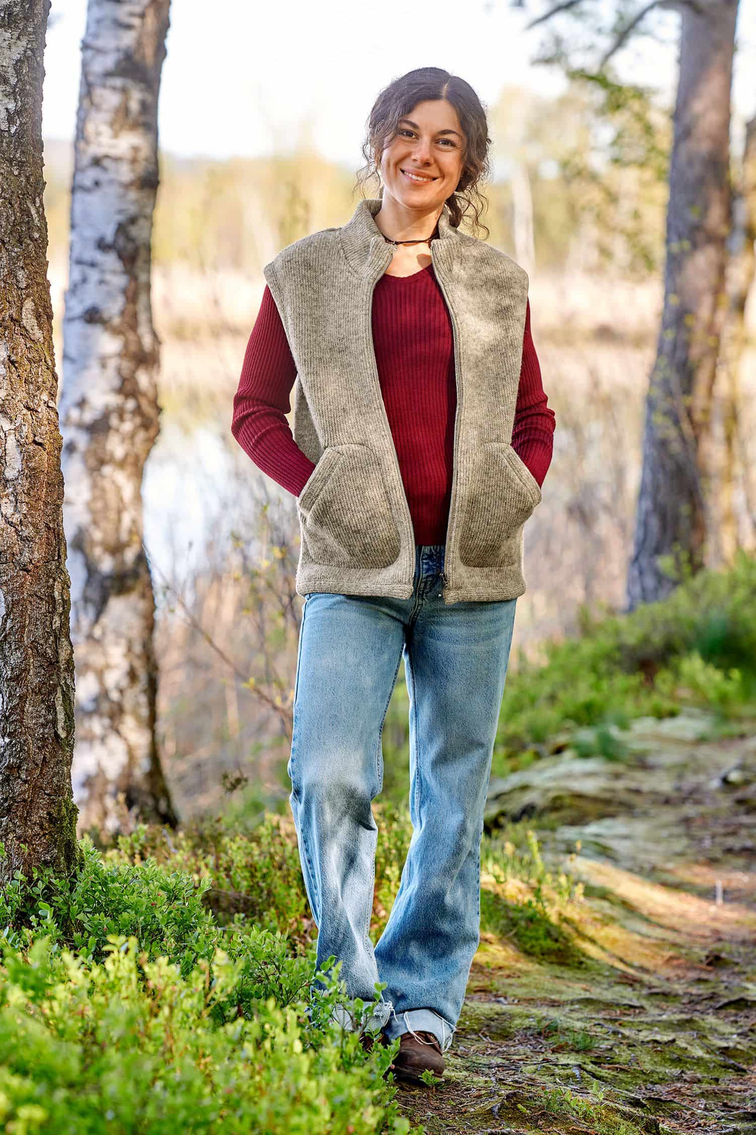 Frau trägt die graue ungefärbte Finkhof Wollwalkweste aus bio Wolle (kbT) ohne Ärmel mit rotem Shirt