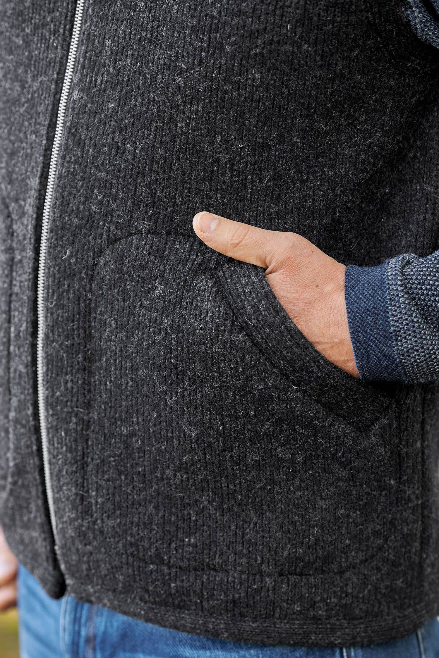 Hände in der Tasche der anthrazitfarbenen Wollwalkweste ohne Ärmel aus bio Wolle (kbT) vom Finkhof