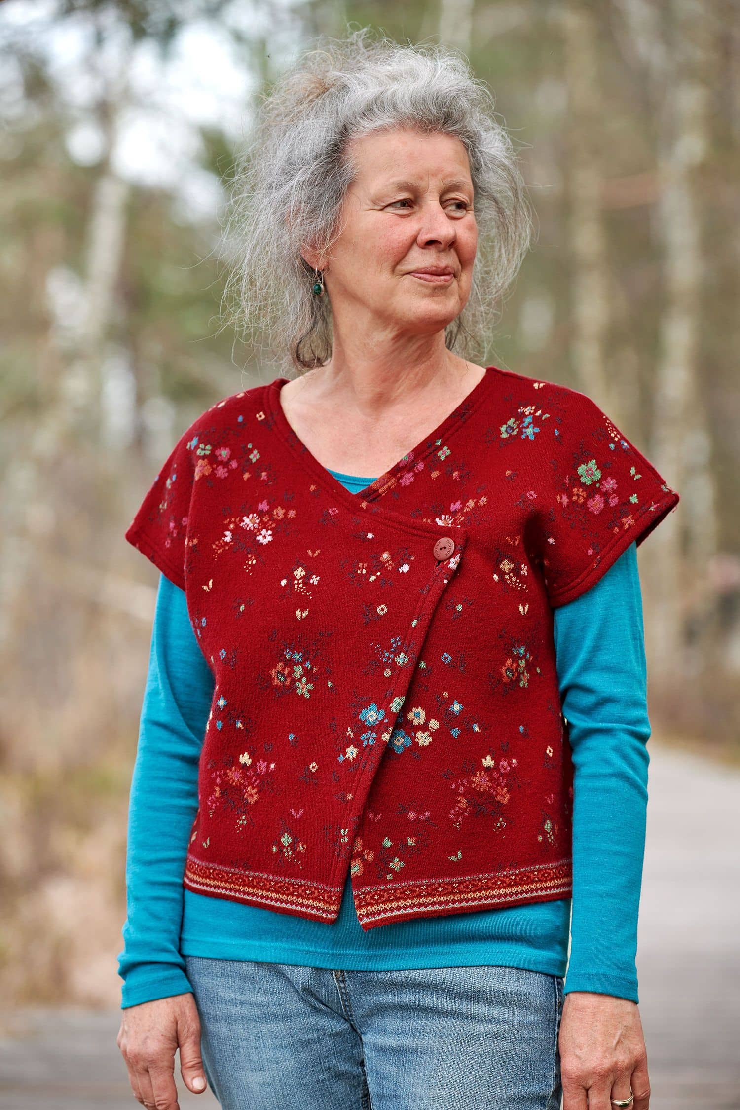 Frau trägt türkises Langarmshirt aus bio Wolle (kbT) und Seide mit roter Weste