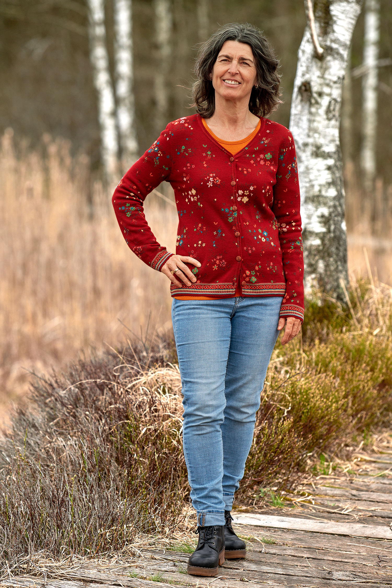 Frau trägt roten Cardigan aus bio Merinowolle (kbT) und bio Baumwolle (kbA)