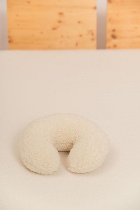 naturweißes Nackenhörnchen vom Finkhof mit Wollplüschbezug aus bio Wolle (kbT) auf hellem Laken mit Zoom