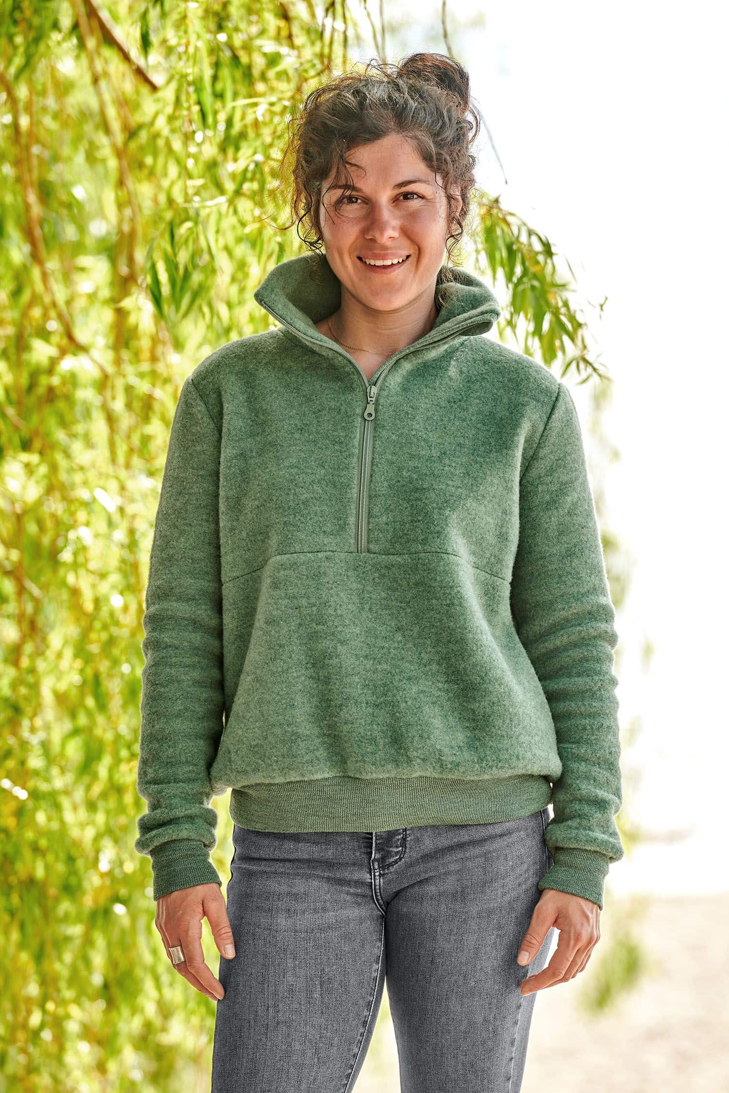 Frau trägt grünen Wollfleece Pullover mit Reißverschluss aus bio Wolle (kbT) vom Finkhof