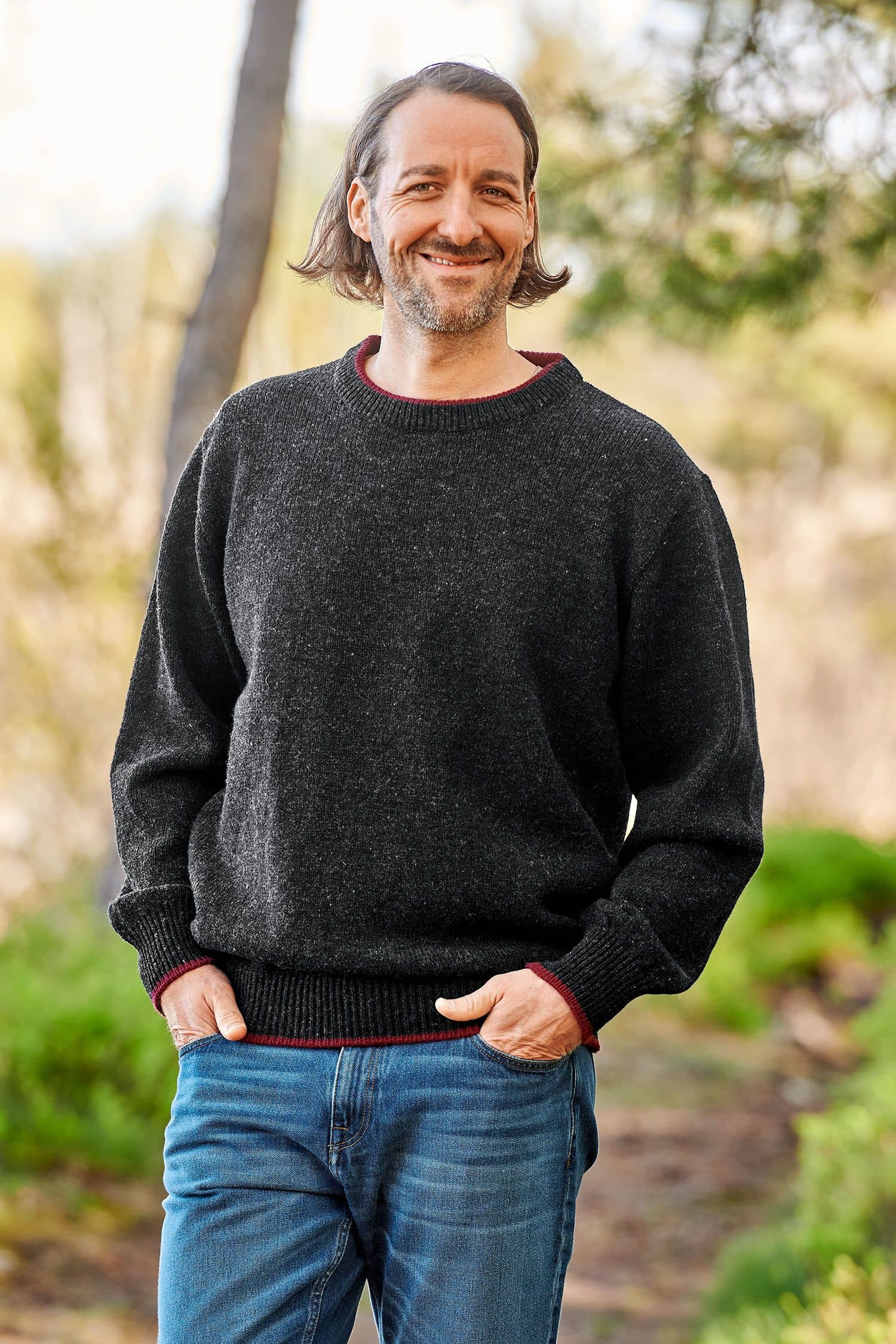 Mann trägt einen anthrazitgrauen Finkhof Pullover aus bio Wolle (kbT)