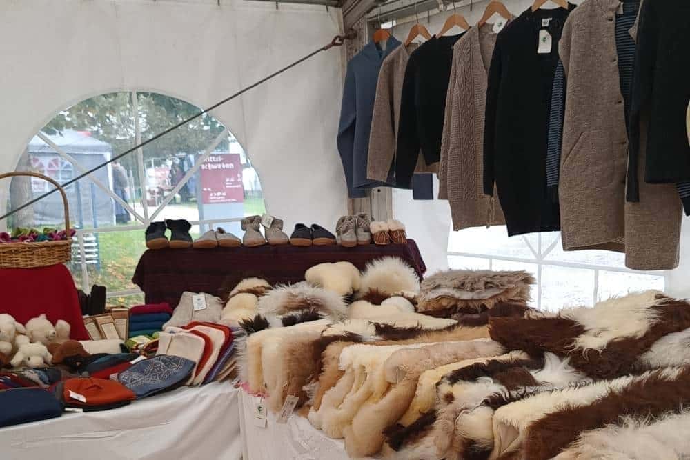 Finkhof Stand in Zelt mit Fellen und Strickjacken