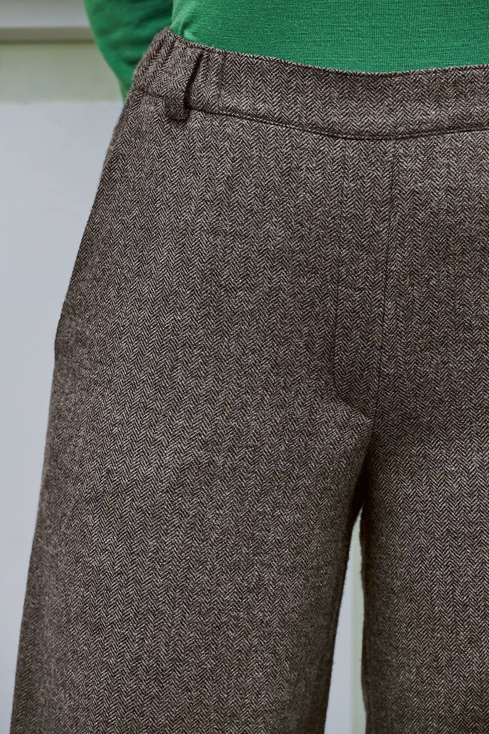 Nahaufnahme vom Bund der braunmelierten Wollhose aus bio Wolle (kbT) vom Finkhof mit grünem Shirt