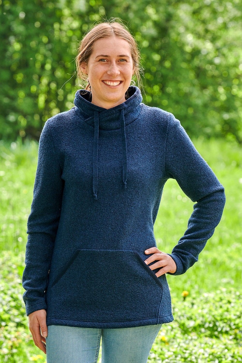 lachende Frau mit Jeans und marineblauem Pullover aus bio Wolle (kbT)