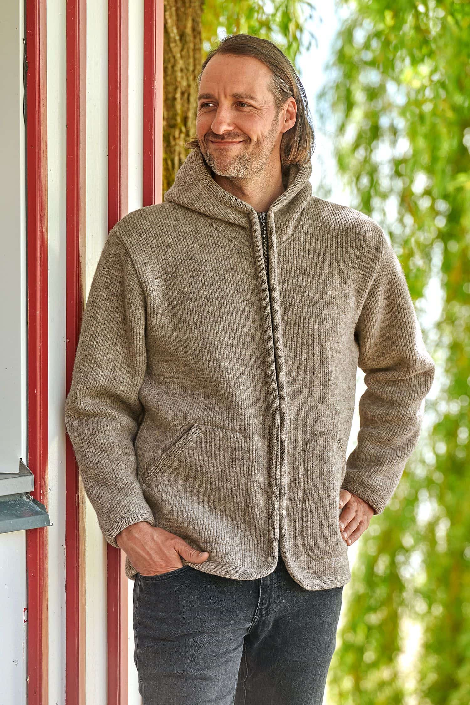 Mann trägt eine graue Kapuzenjacke vom Finkhof aus Walkstoff mit bio Wolle (kbT)