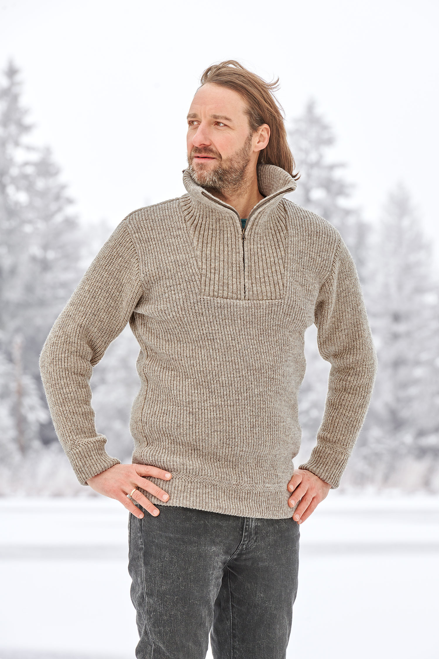 Mann in Schneelandschaft trägt einen grauen Finkhof Troyer aus bio Wolle (kbT)