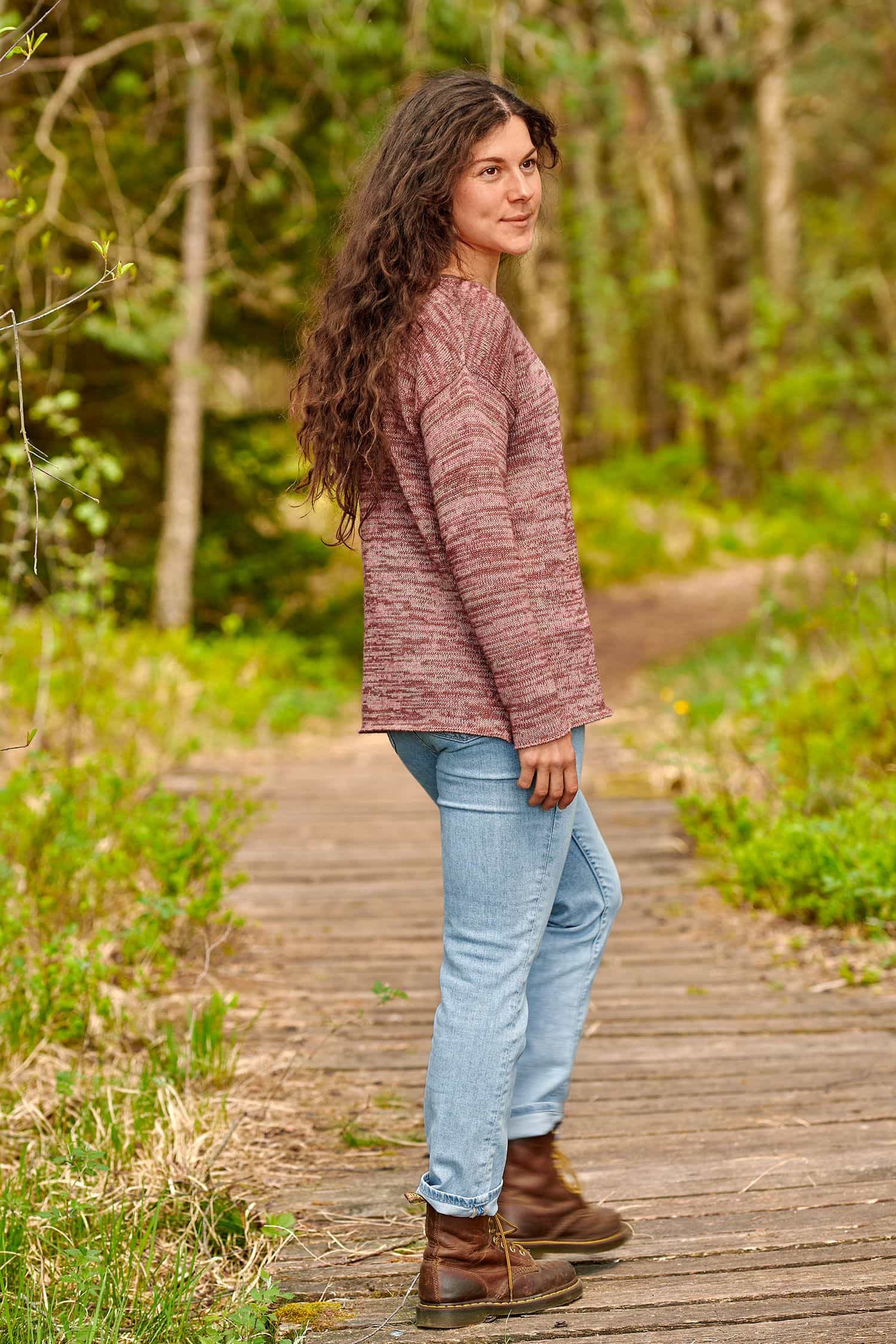Frau mit Jeans trägt rosamelierten Strickpullover aus bio Baumwolle (kbA) und bio Wolle (kbT)