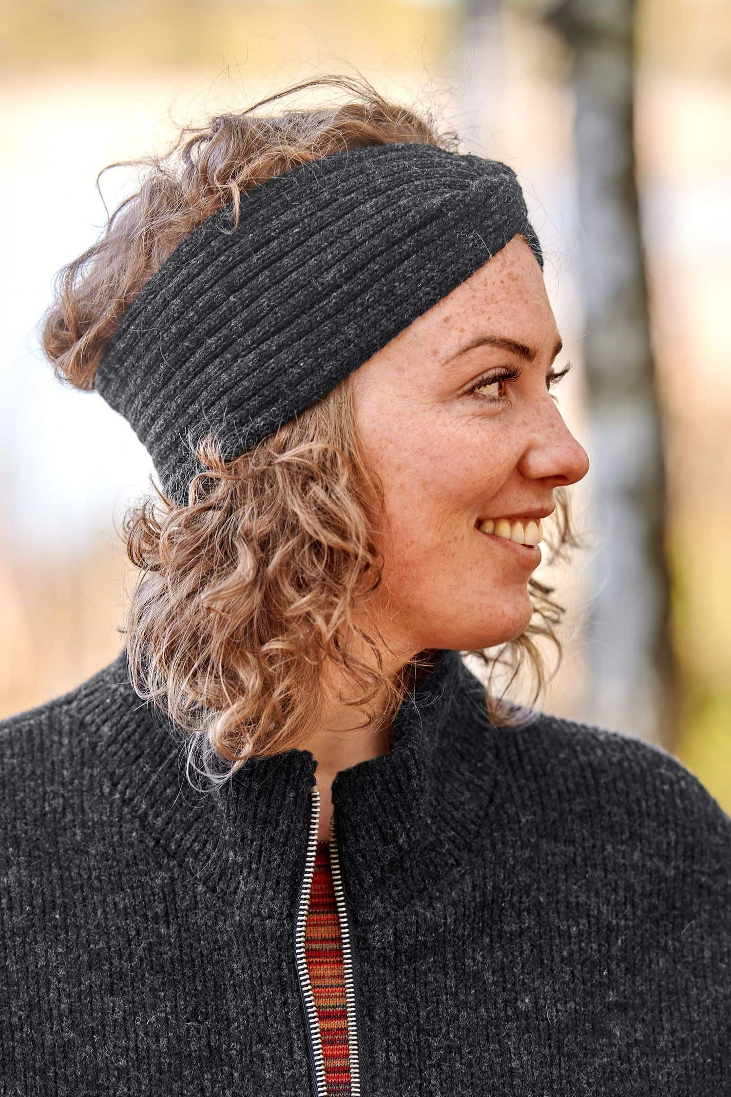 Frau mit grauer Finkhof Jacke trägt ein dunkelgraues Stirnband mit Twist vom Finkhof aus bio Wolle (kbT)