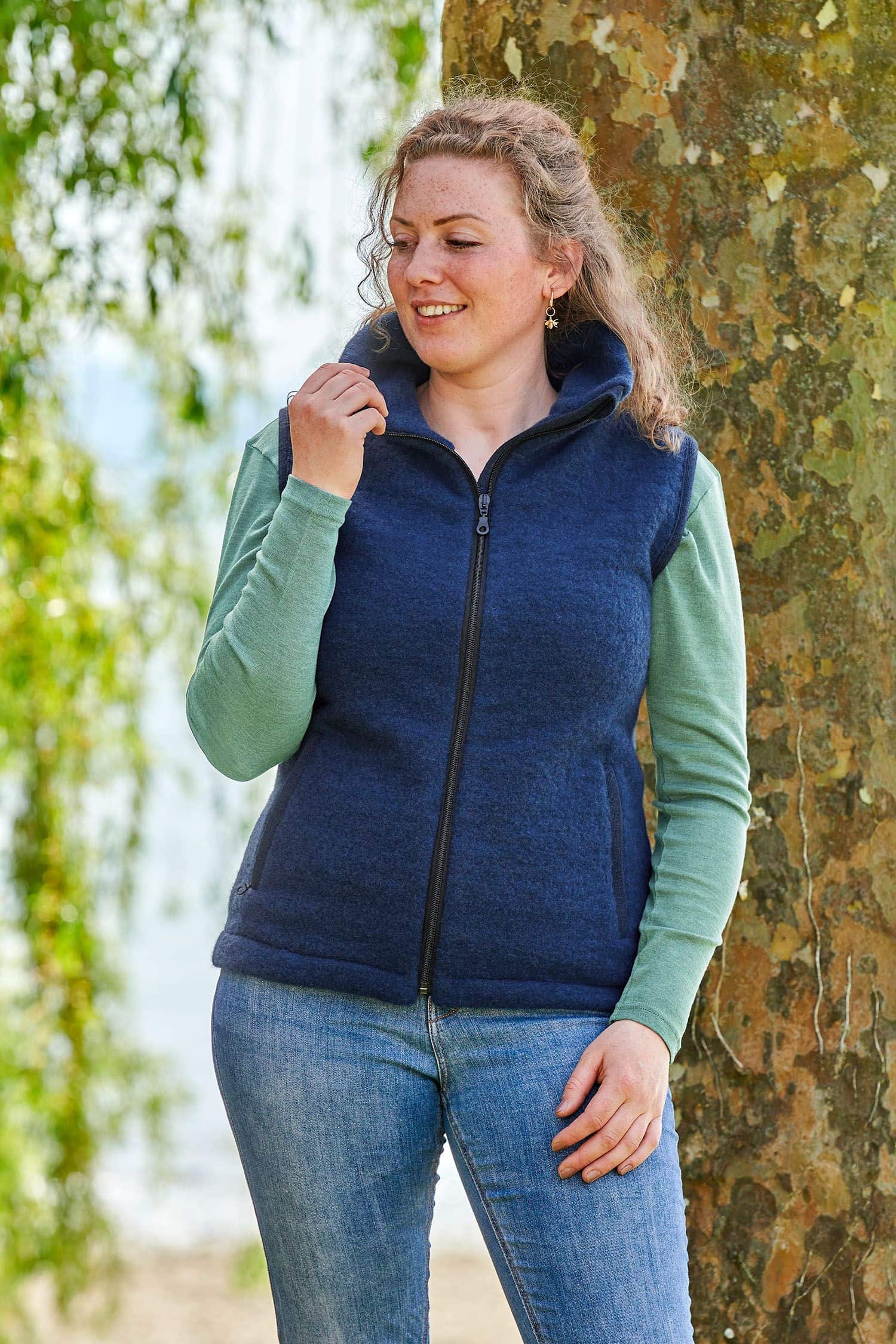 Frau mit grünem Shirt trägt eine blaue ärmellose Weste aus bio Wolle (kbT) vom Finkhof