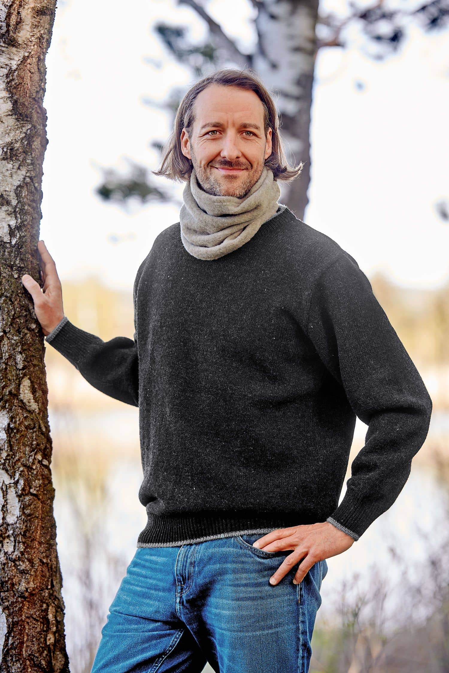 Mann mit grauem Pulli trägt naturmelierten Schlupfschal aus bio Merinowolle (kbT) vom Finkhof