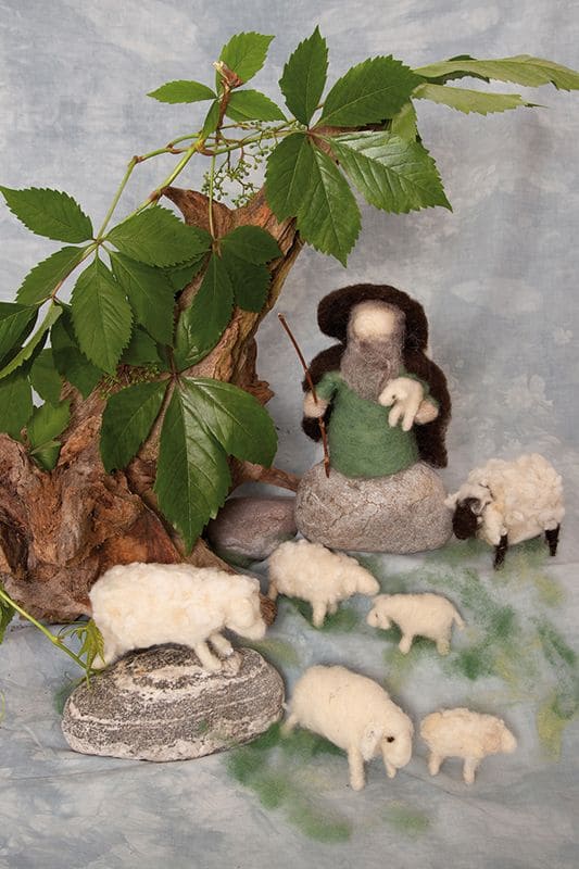 Bastelpackung Schäfer und Schafe selbstgebastelte Schäferfigur und Schafe auf Steinen unter einem Ast mit der Finkhof Bastelpackung aus bio Wolle (kbT)