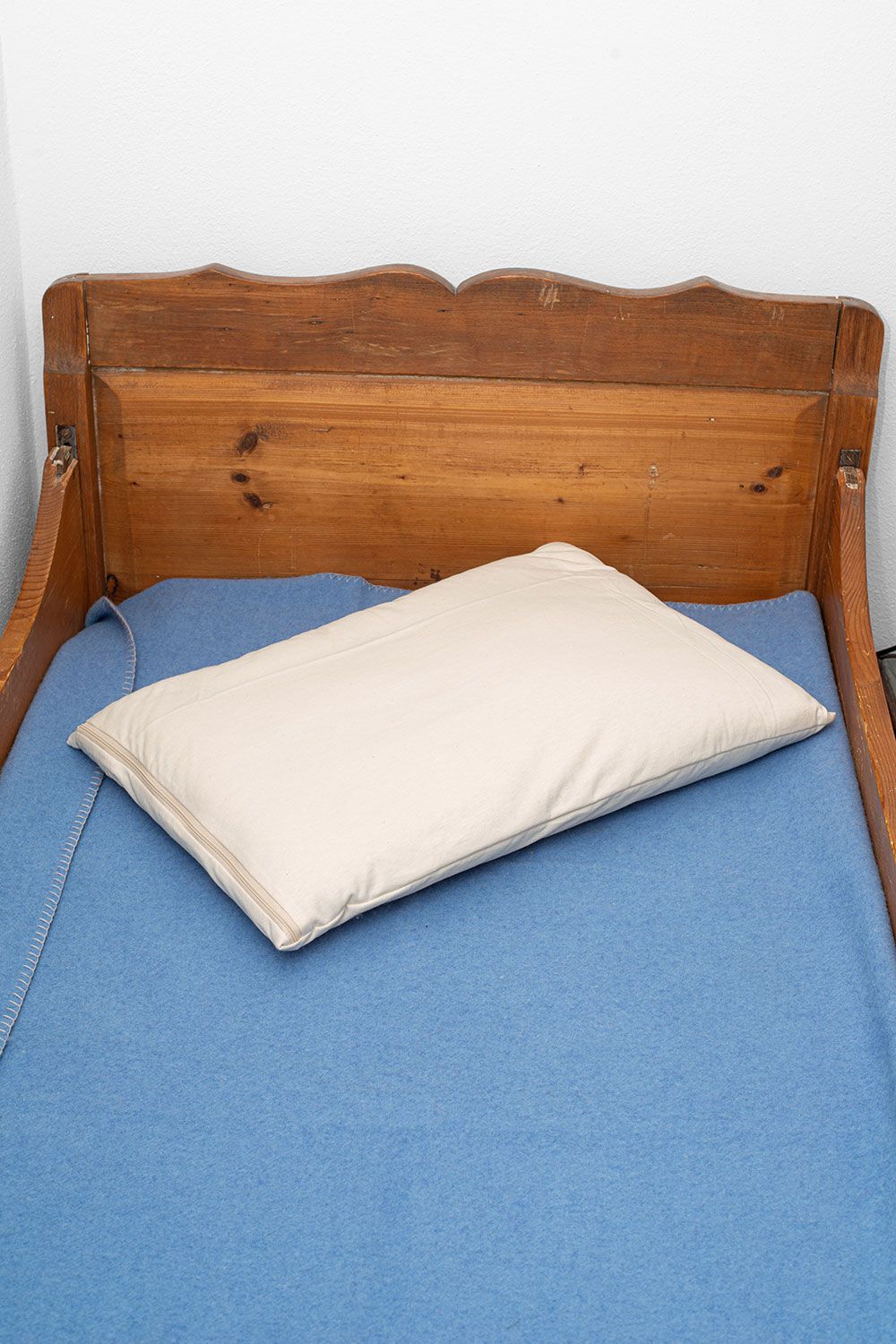 Kinderkissen Strickstoff 40 x 60 cm Finkhof Kinderkissen in braunem Bett mit blauem Laken aus bio Wolle (kbT) und bio Baumwolle (kbA)