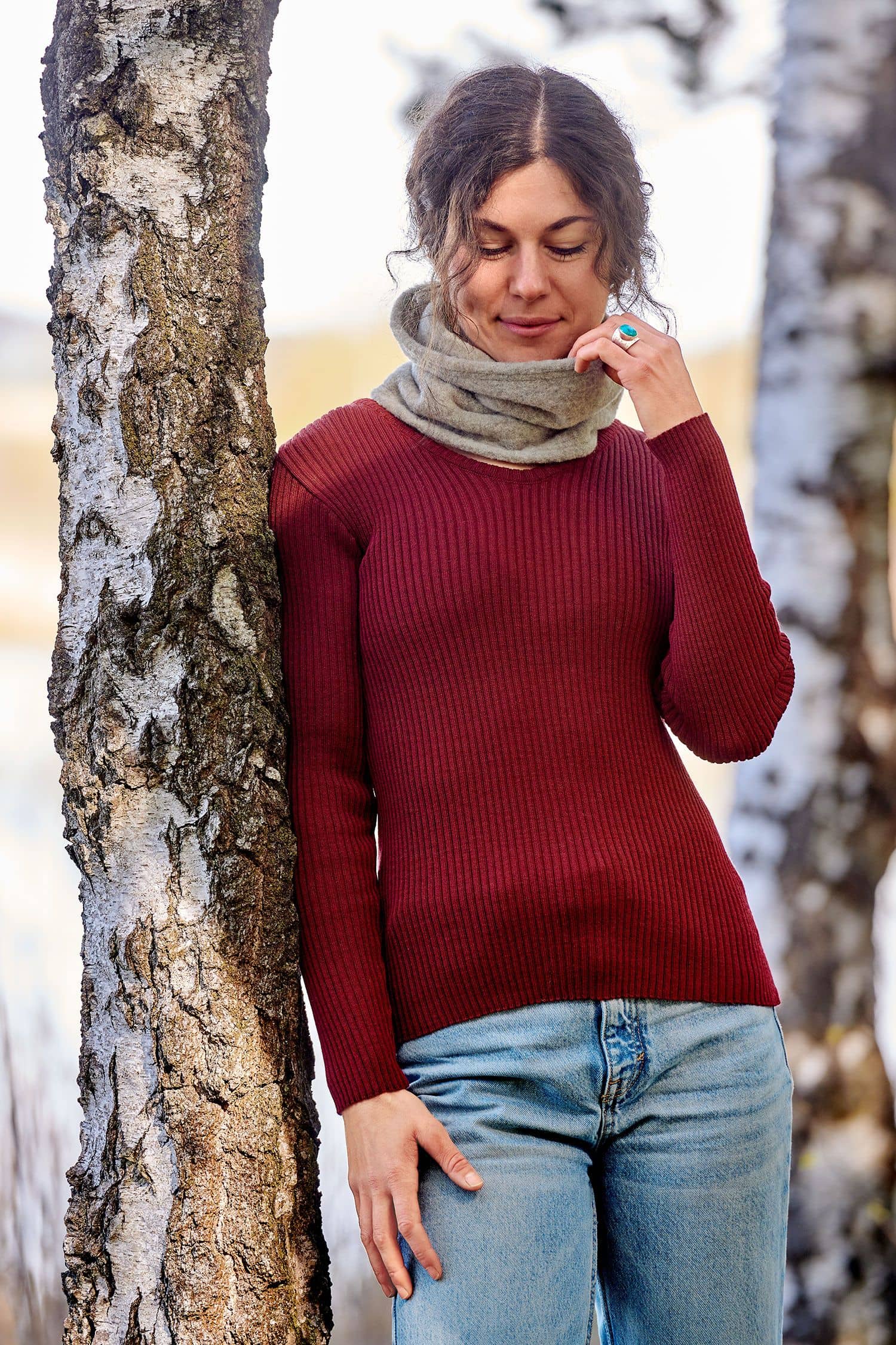 Frau mit rotem Pulli trägt naturmelierten Schlupfschal aus bio Merinowolle (kbT) vom Finkhof