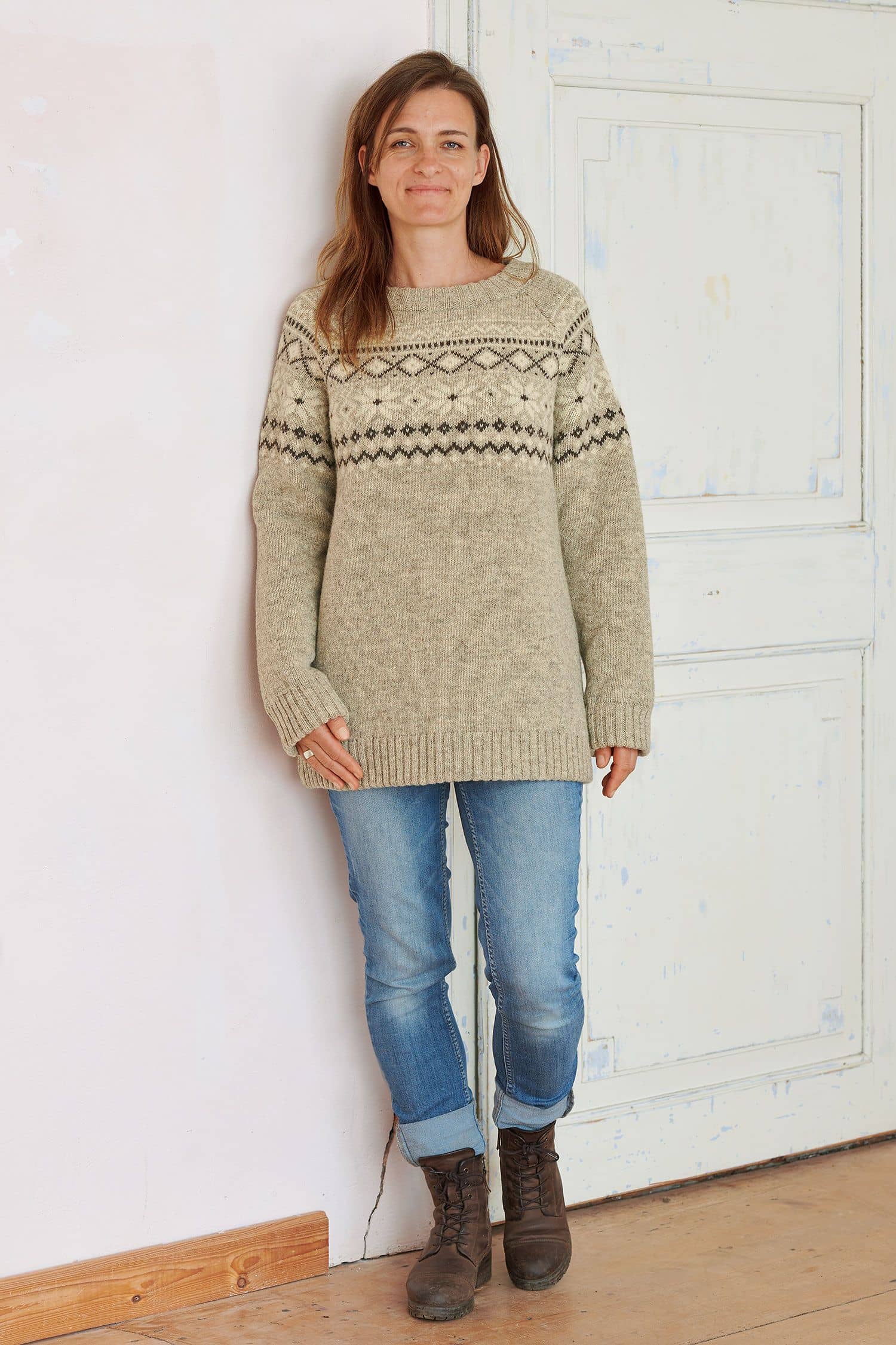 Frau trägt Jeans und grauen Finkhof Norwegerpulli aus bio Wolle (kbT)