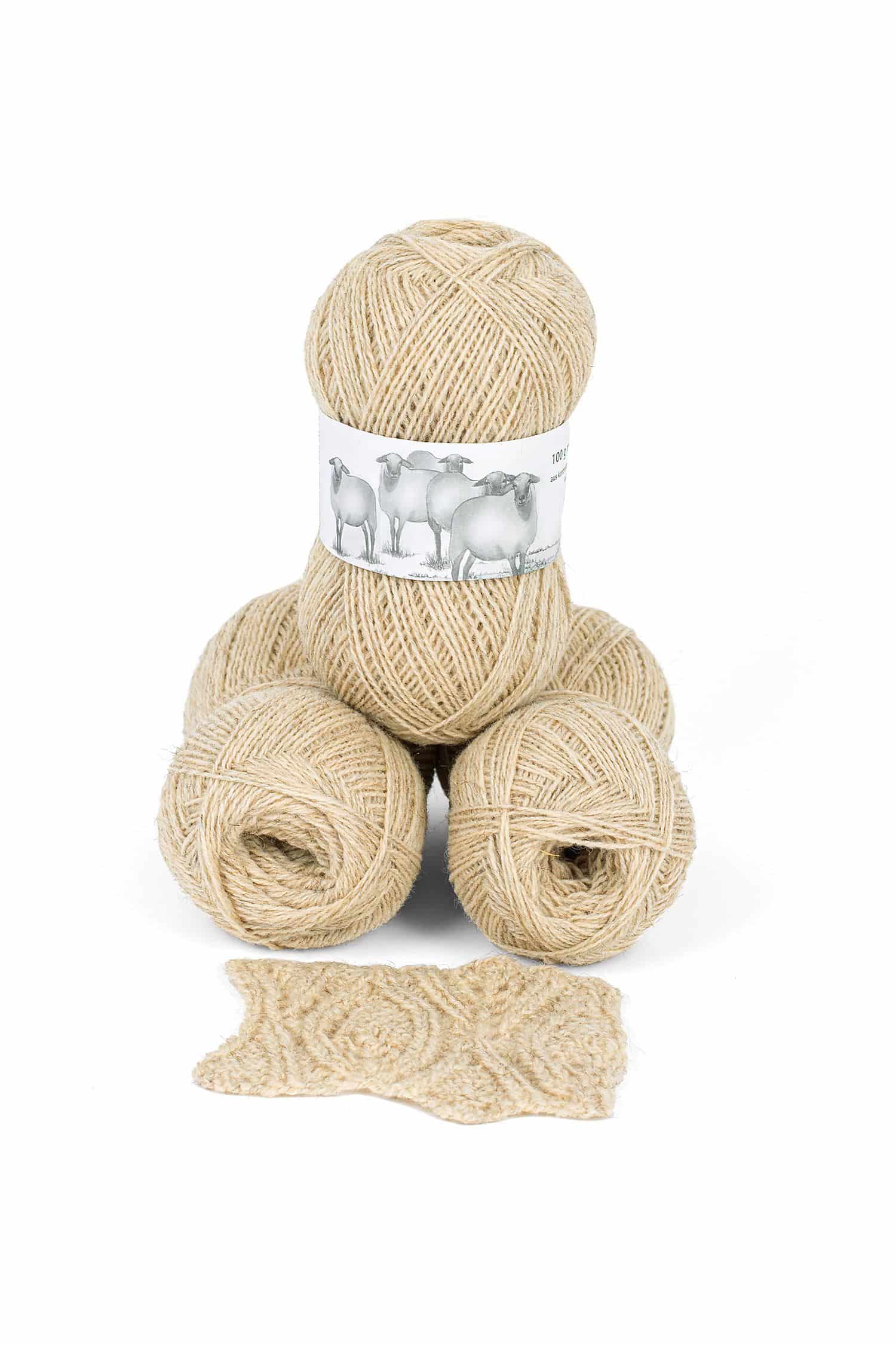 Wollknäule aus dünnem ungefärbten bio Wollgarn vom Coburger Fuchsschaf aus (kbT) vom Finkhof mit gestricktem Stück davor