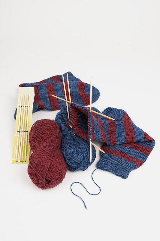 Nadelspiel Bambus Nadelspiel aus Bambus mit roten und blauen Wollen und Strickstück