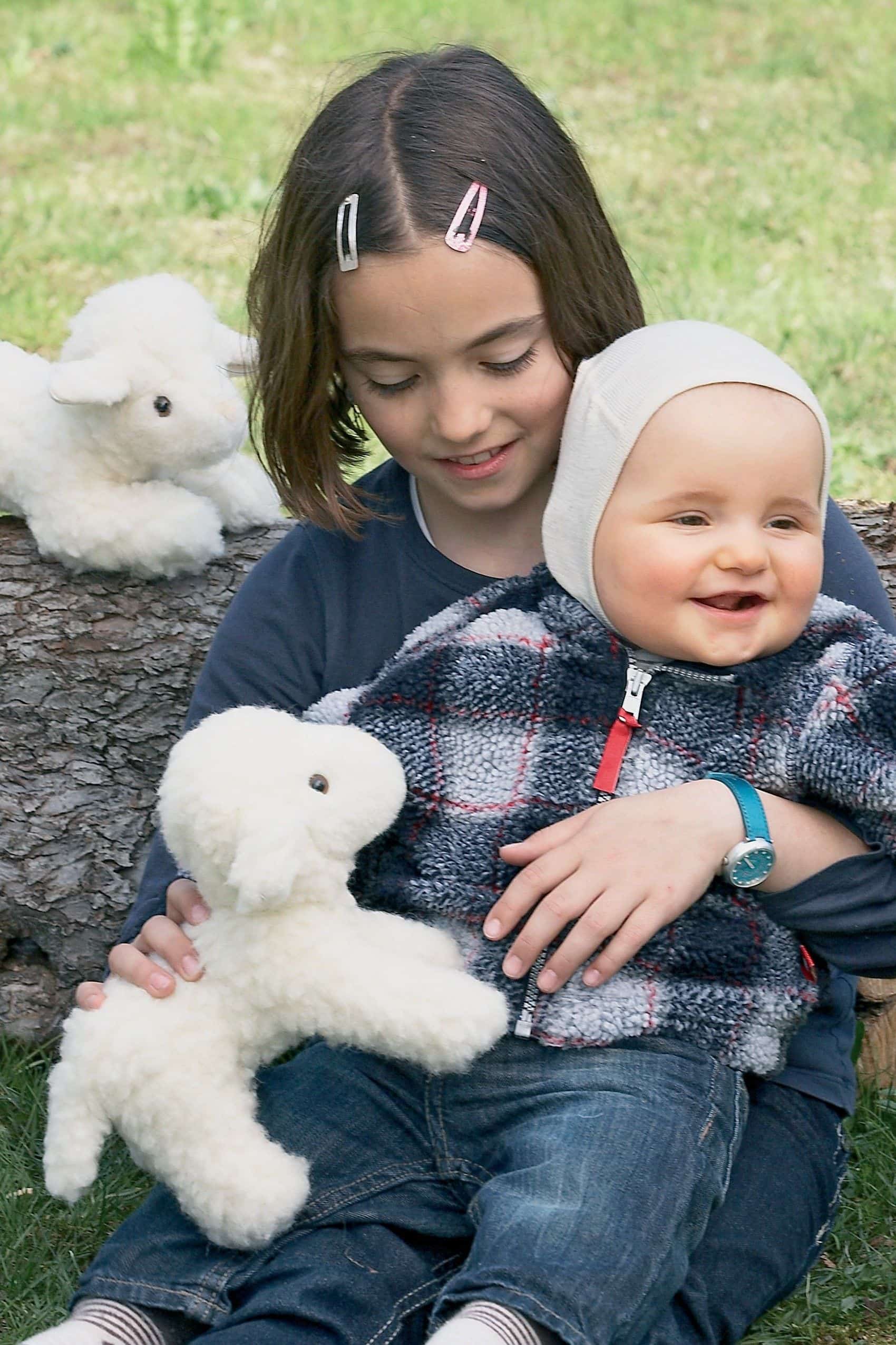 Kinder spielen mit einem stehendem Lamm als Kuscheltier in naturweiß mit Sicherheitsaugen