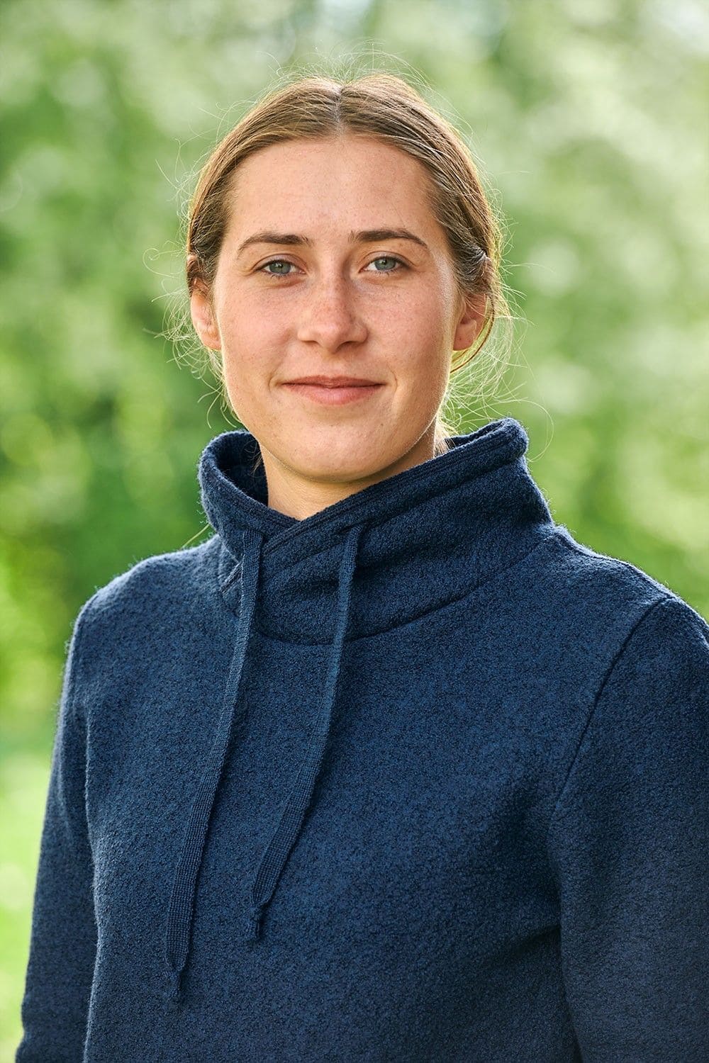 Portraitaufnahme von Frau mit marineblauem Pullover aus bio Wolle (kbT)